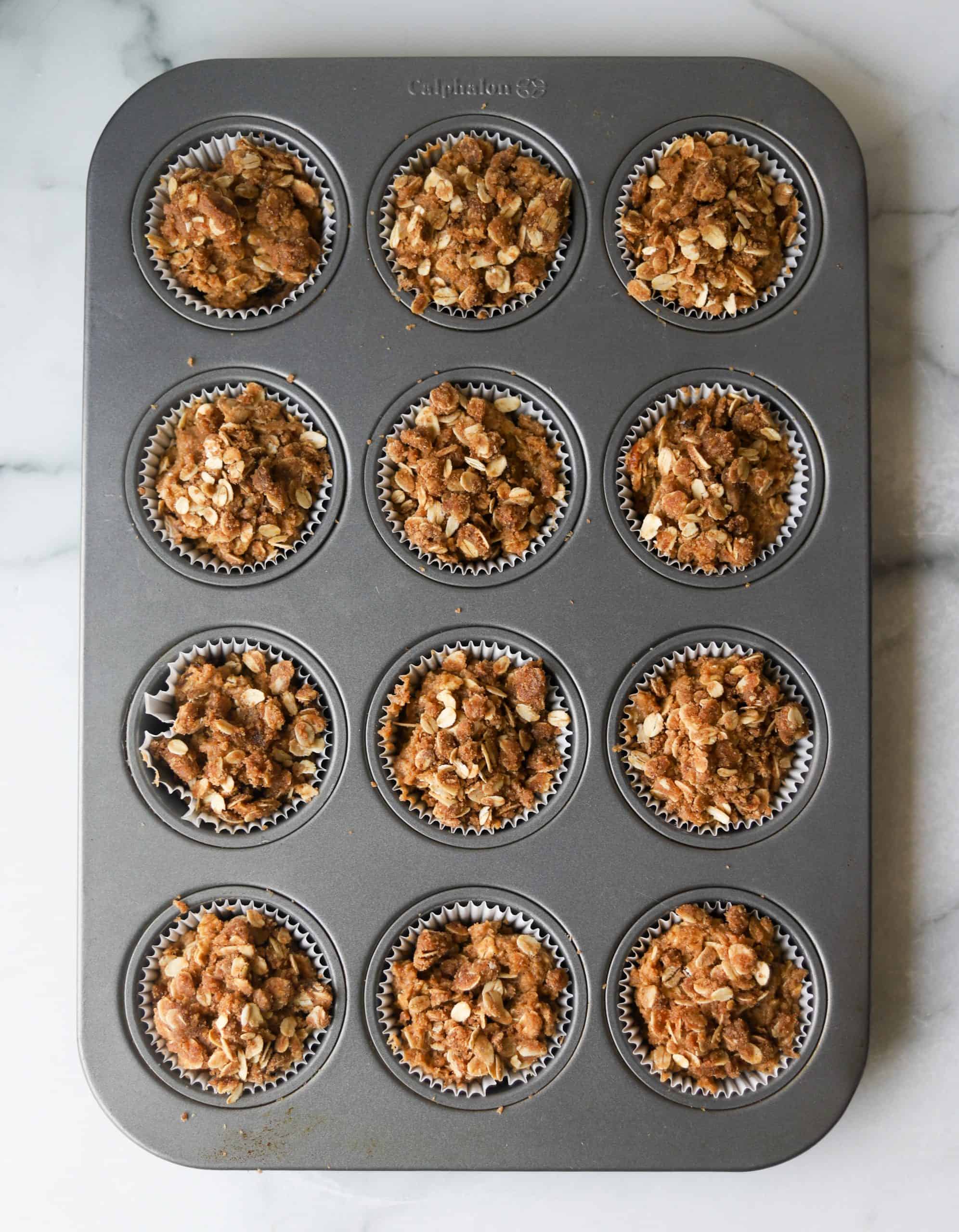 A muffin tray filled with coffee cake batter.
