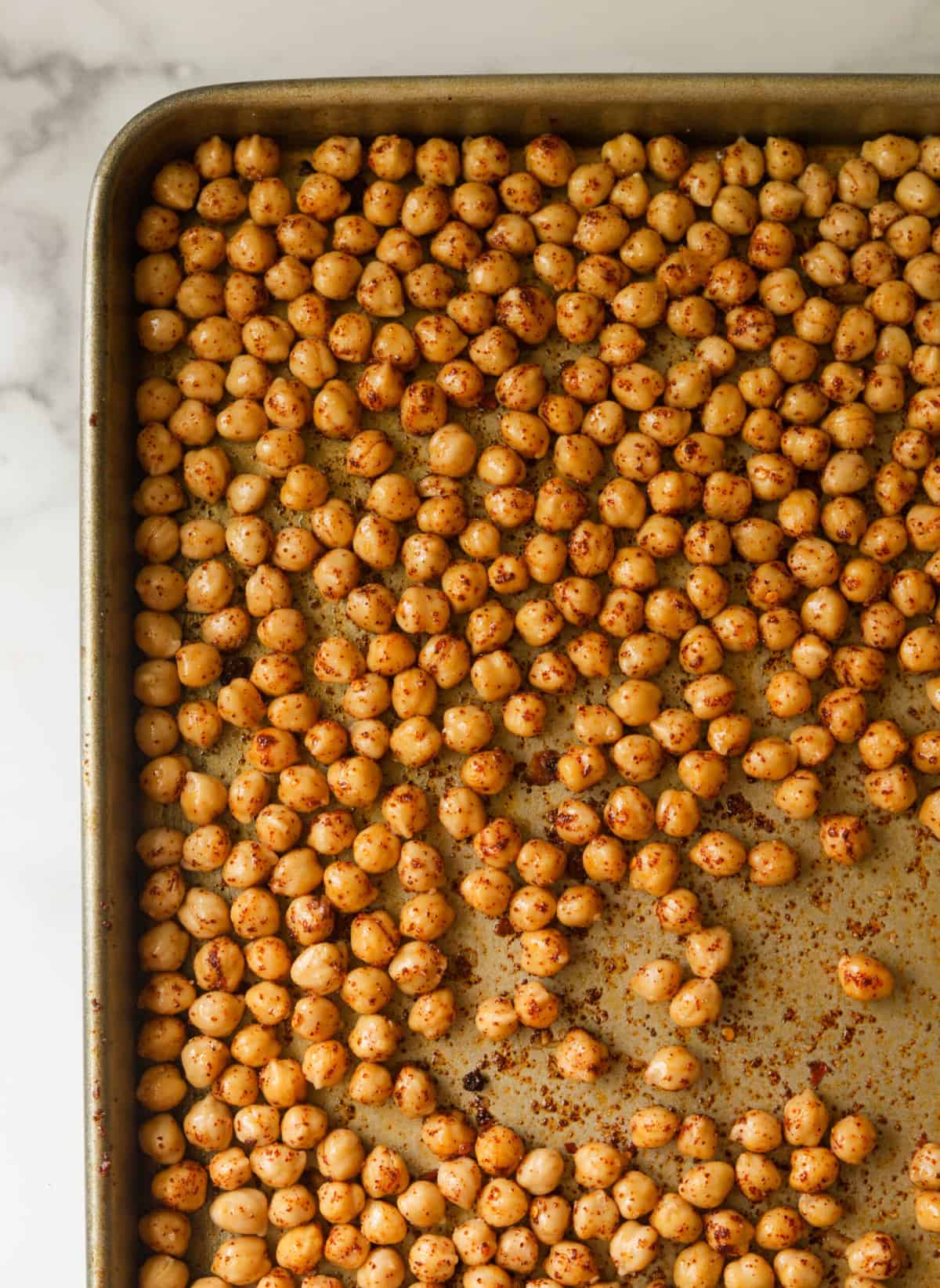 An overhead shot of a pan of chickpeas coated in spices.