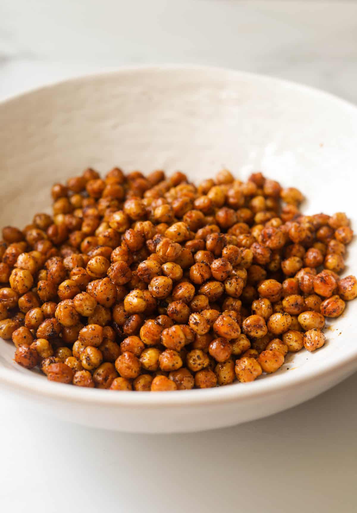 A white bowl filled with spicy roasted chickpeas.