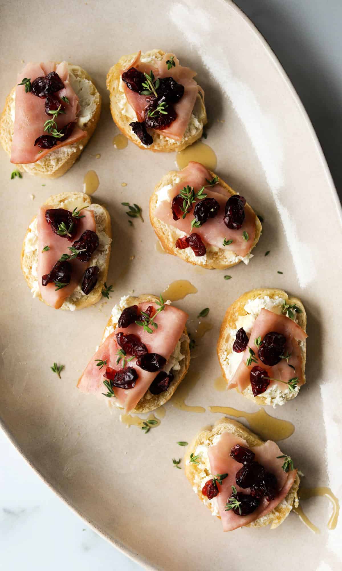 An overhead shot of goat cheese crostinis on a platter.