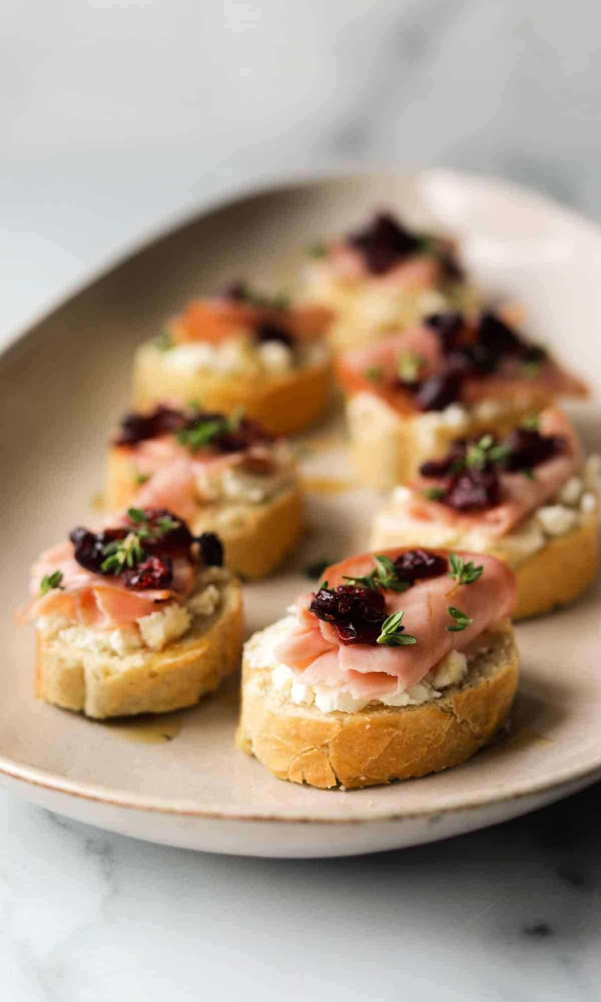 A front shot of a platter of goat cheese crostinis.