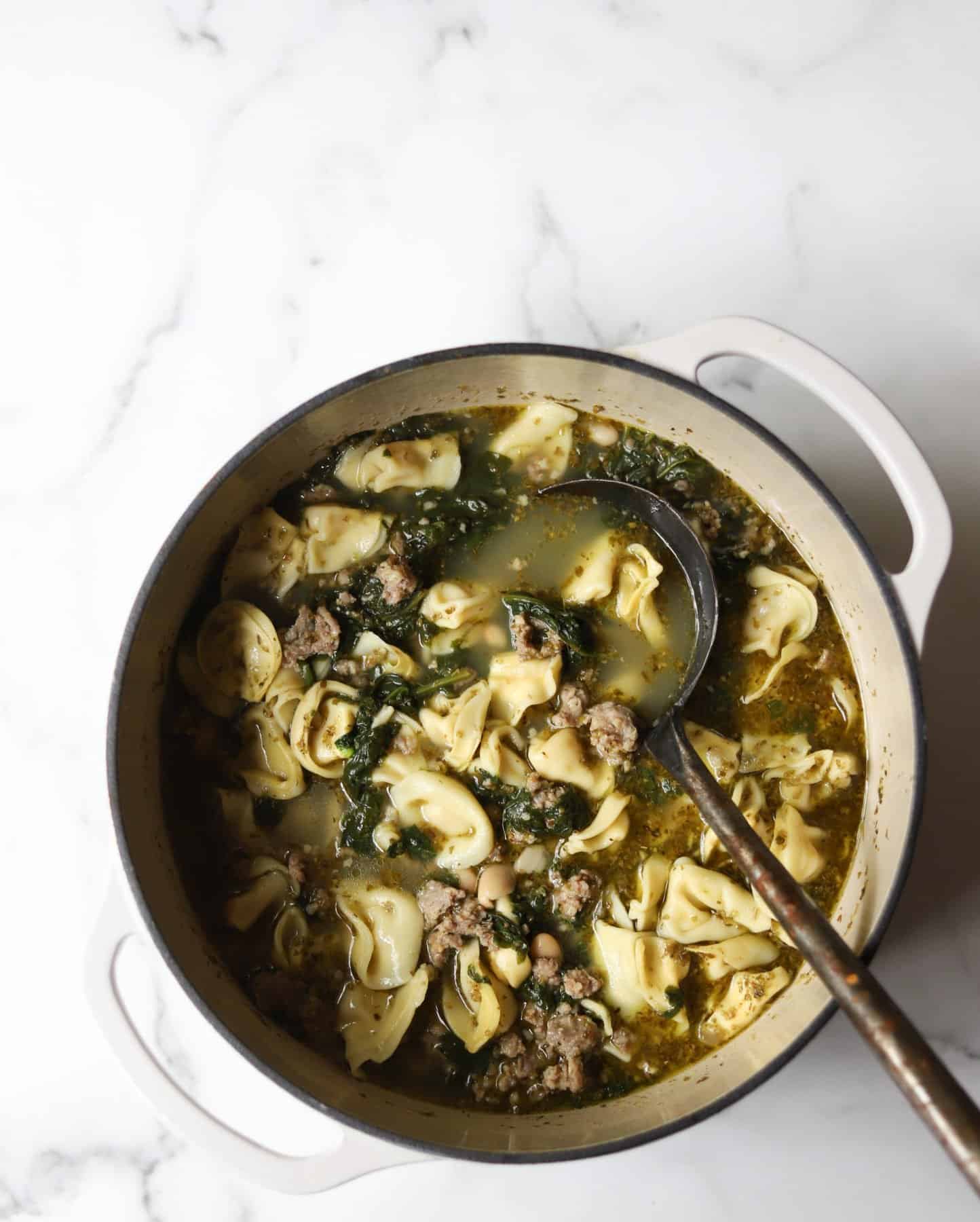 Tortellini soup in a white pot