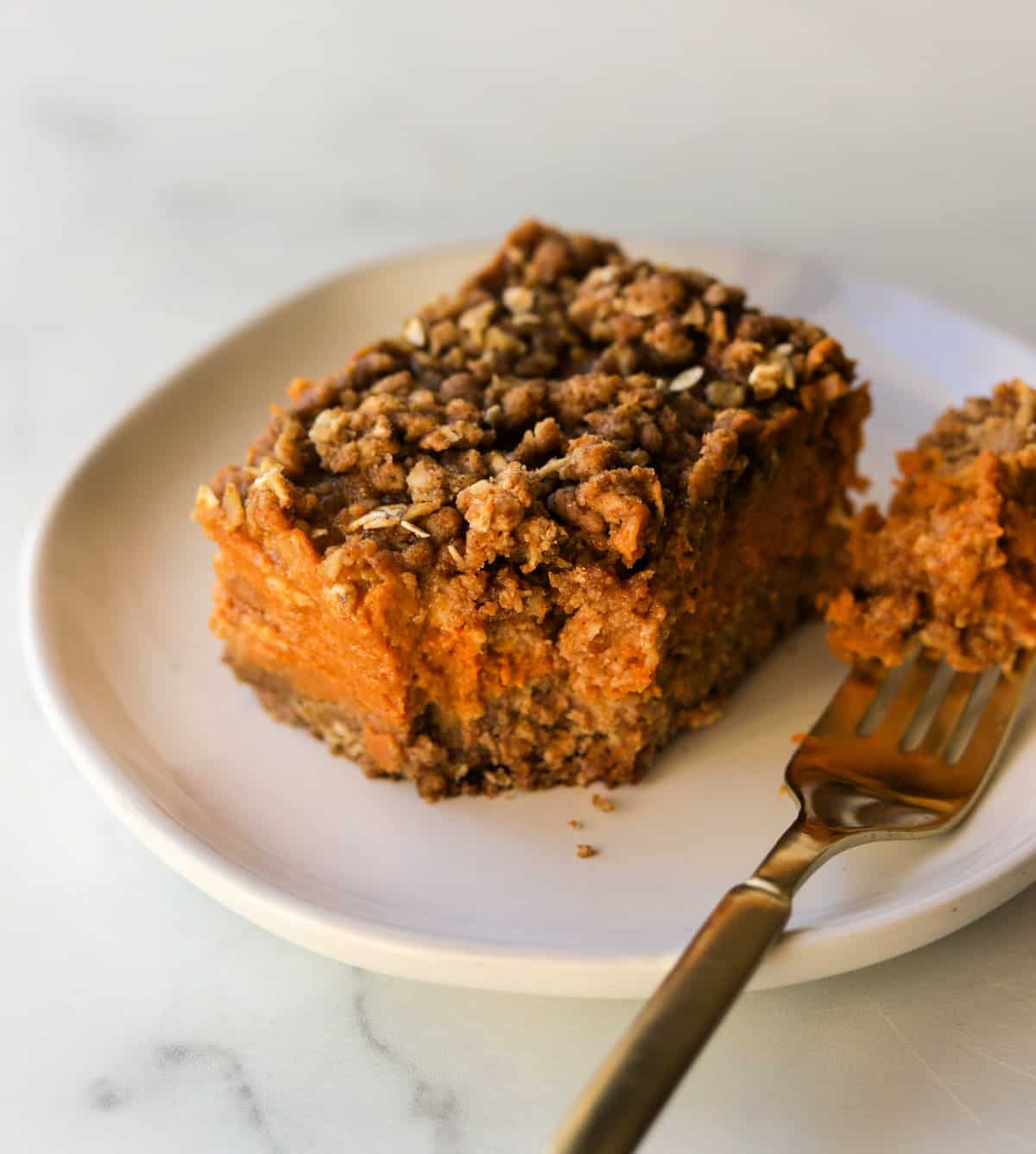 A front angled shot of a pumpkin crumb bar with a bite taken out of it on a fork.