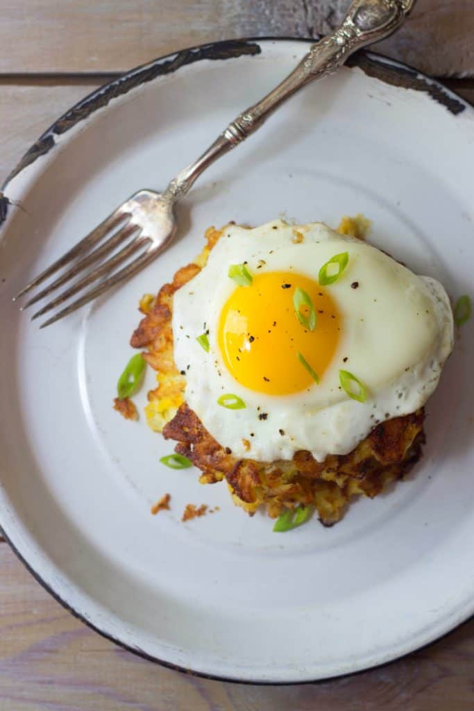 Hash brown haystacks with a fried egg on a white plate