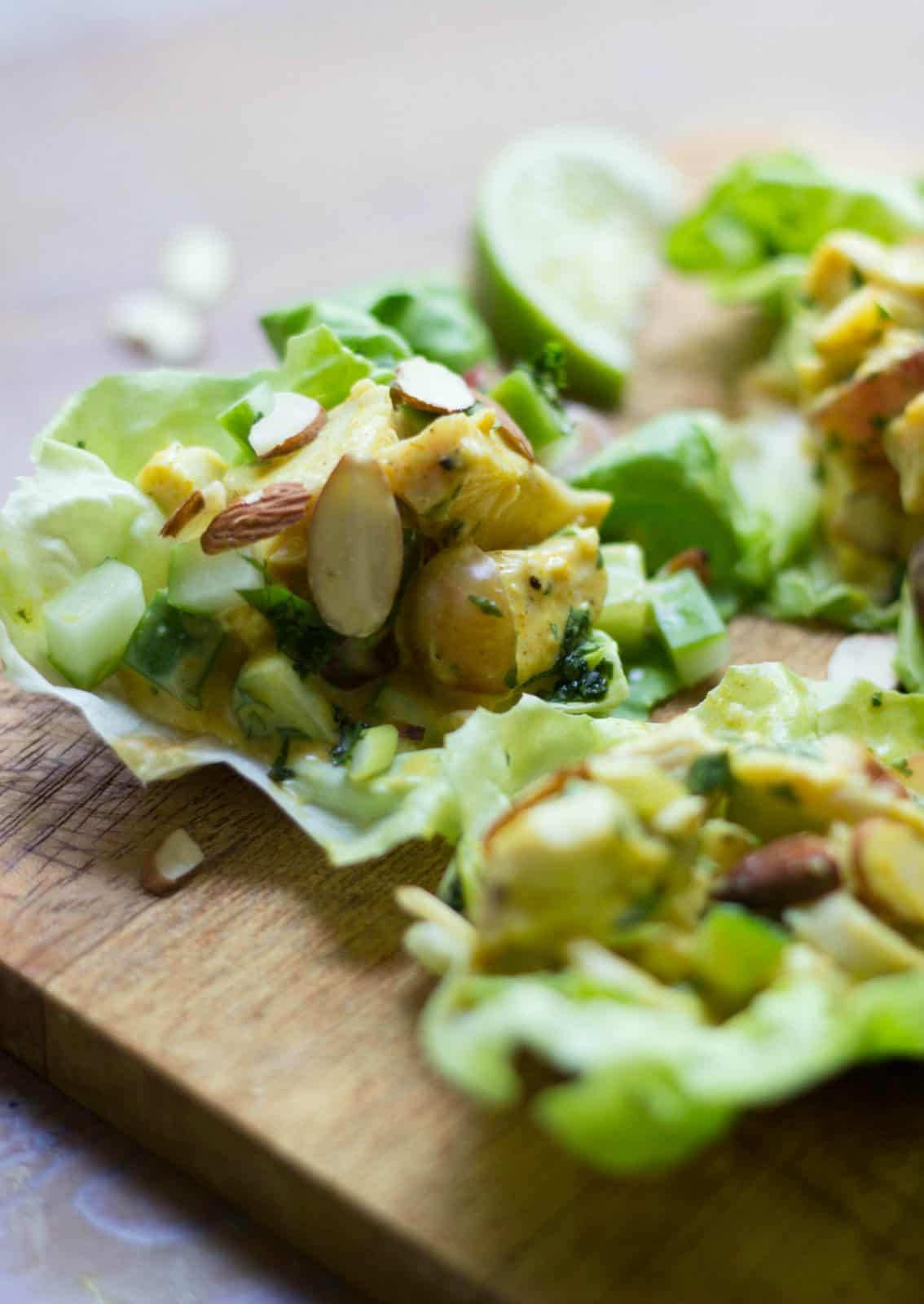 Close up of turkey salad lettuce wraps on a wood cutting board.