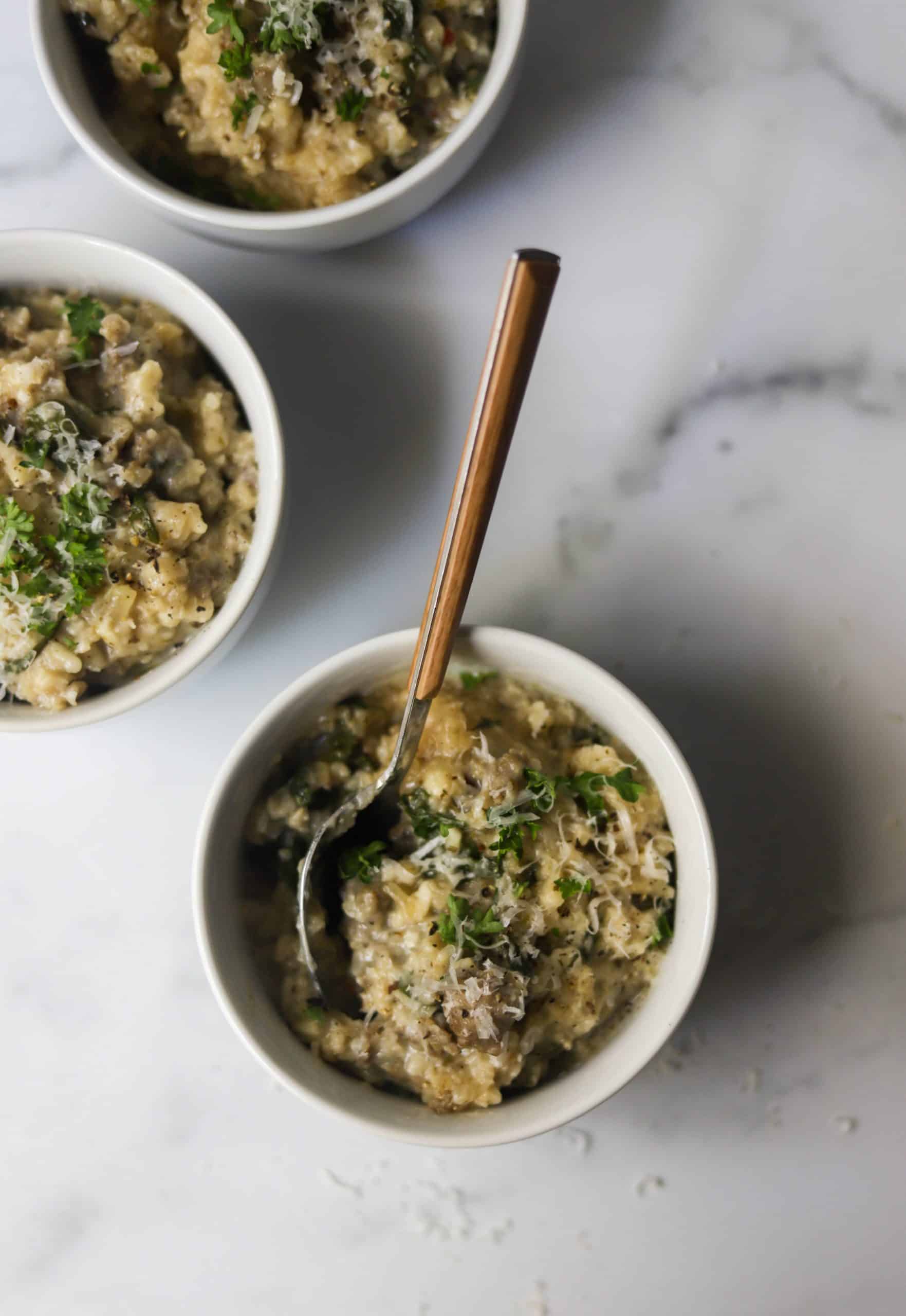 Bowls of risotto on a marble backdrop.