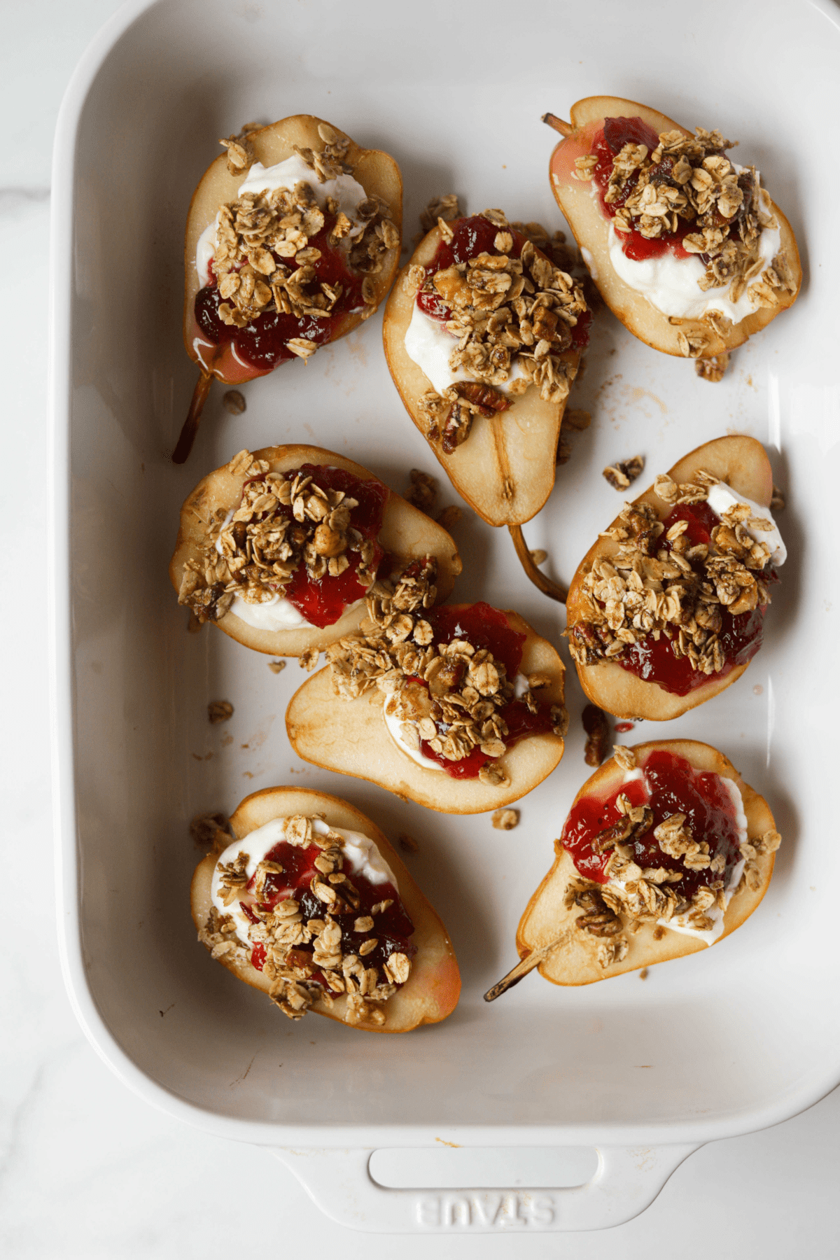 An overhead shot of a baking dish filled with cranberry stuffed pears.