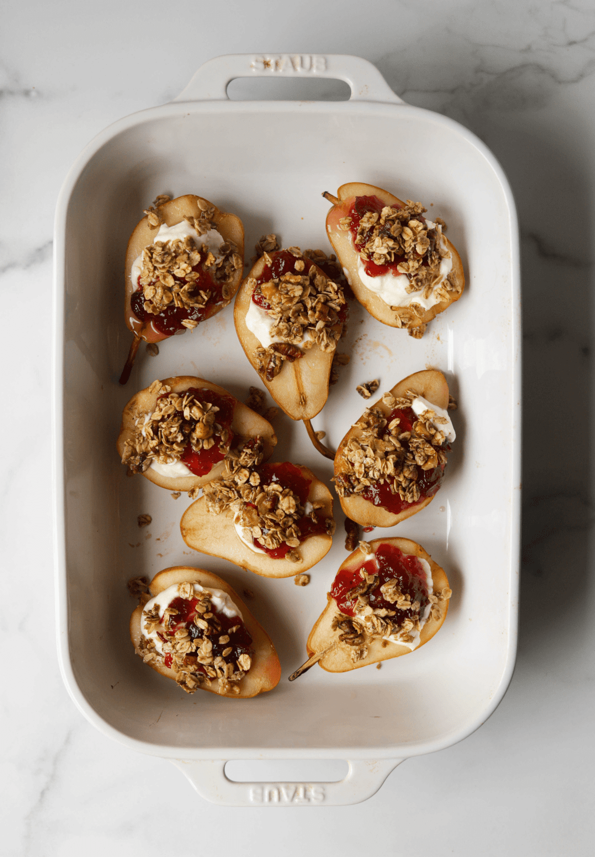 An overhead shot of baked pears with a cranberry goat cheese filling.