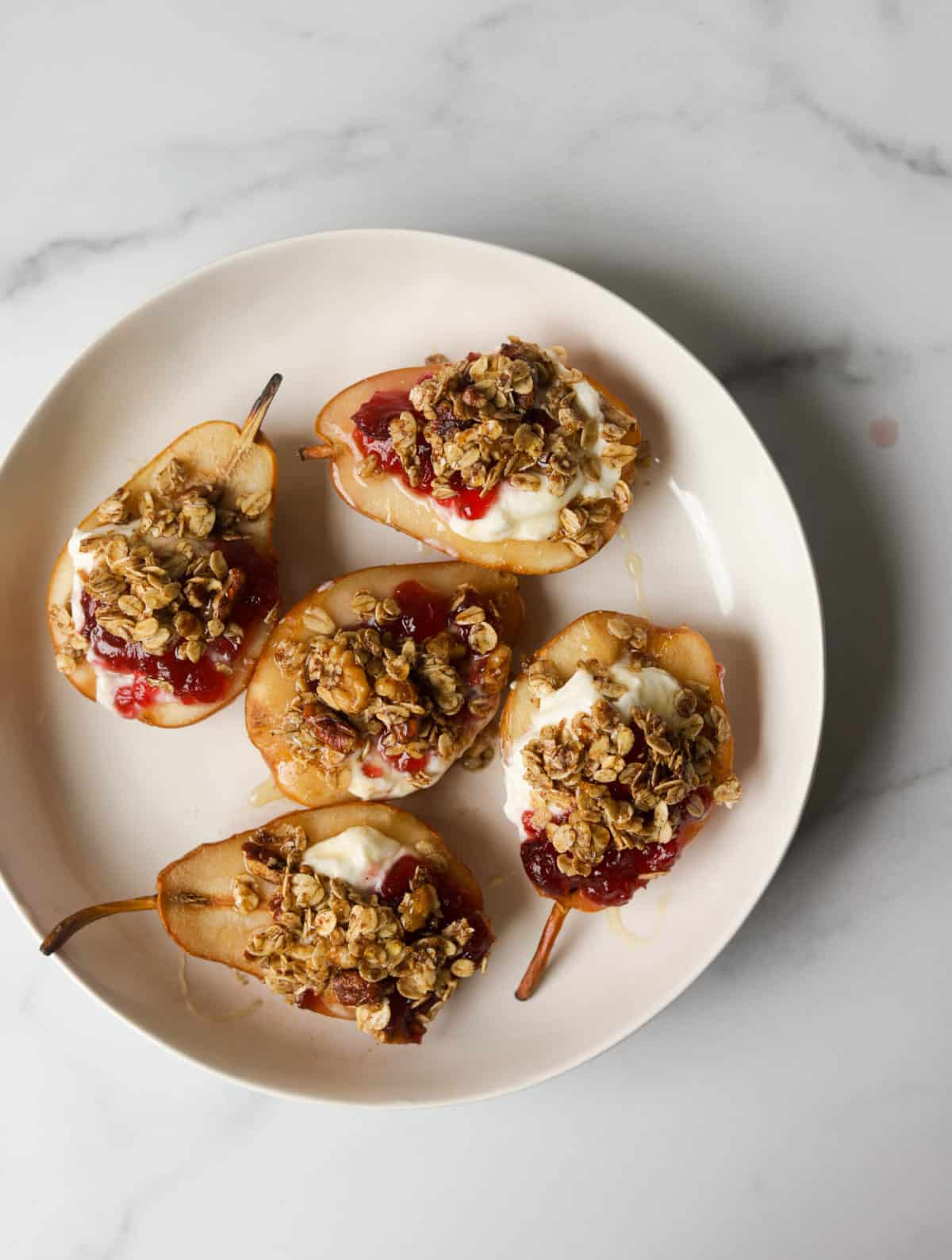 A birds eye view of a plate filled with cranberry stuffed pears.