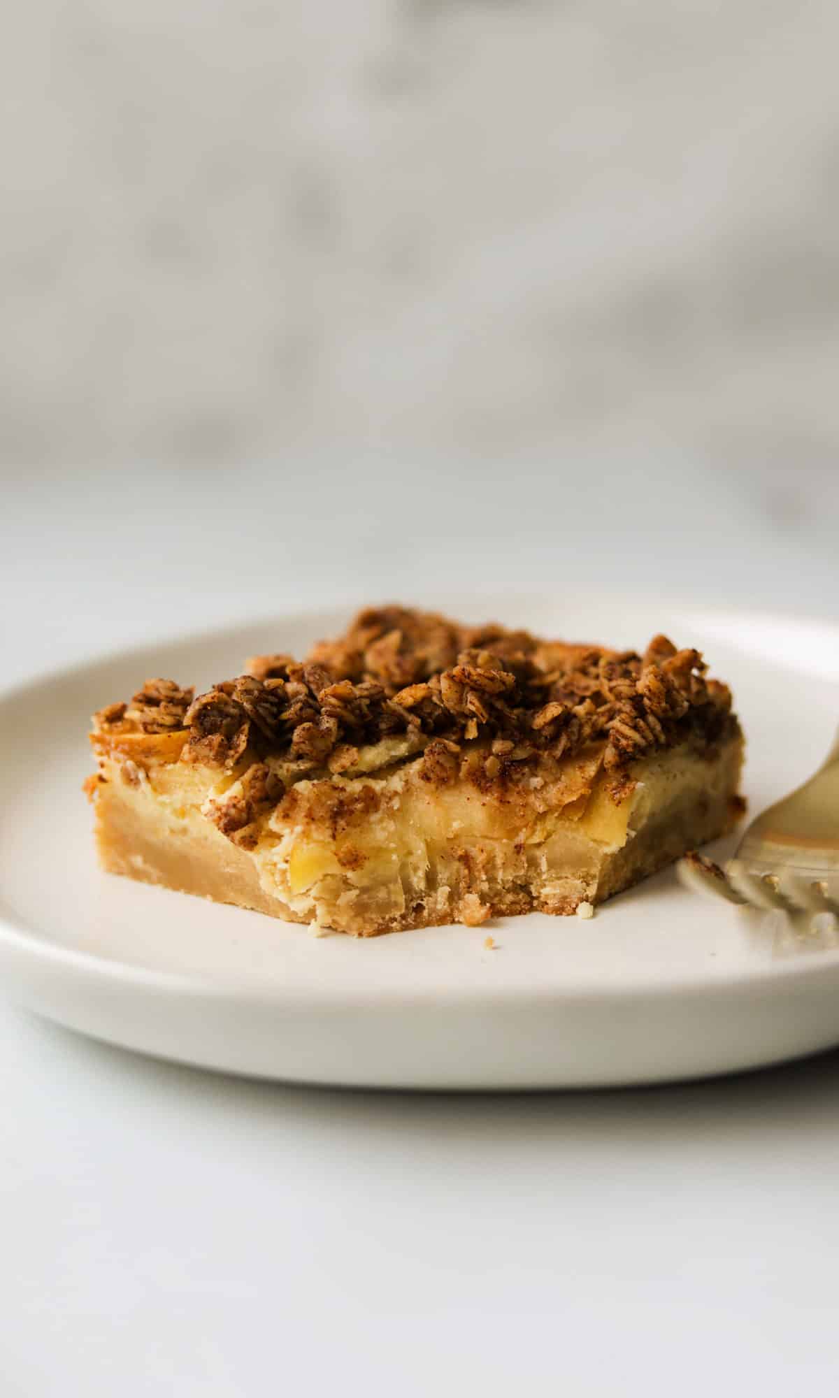 A side shot of an apple crisp bar with a bite taken out of it.