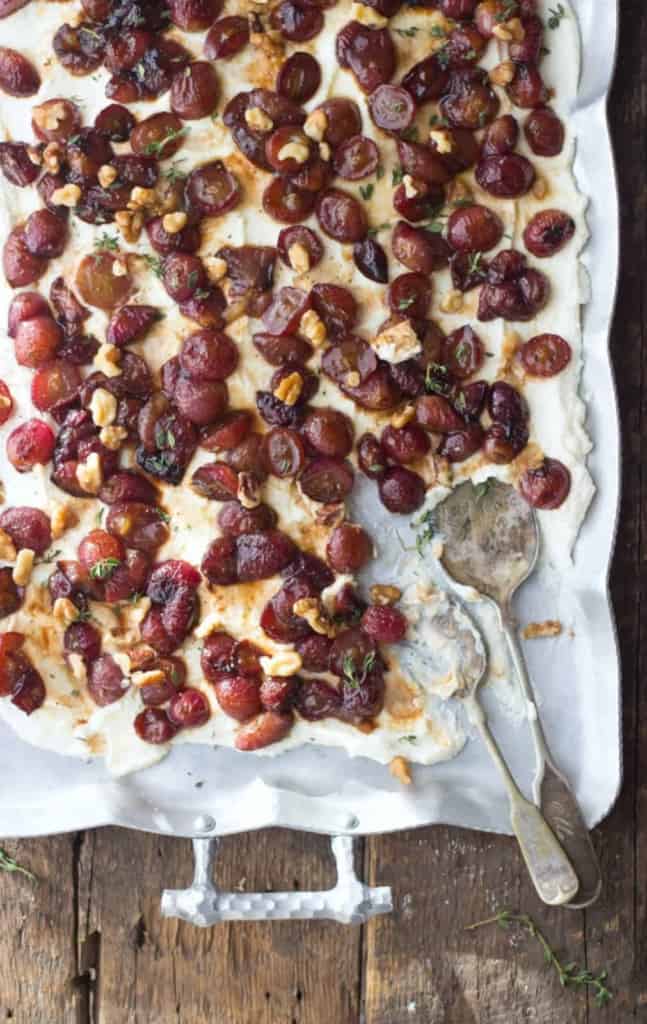 Overhead shot of roasted balsamic grapes & creamy lemon ricotta dip in a white dish. 