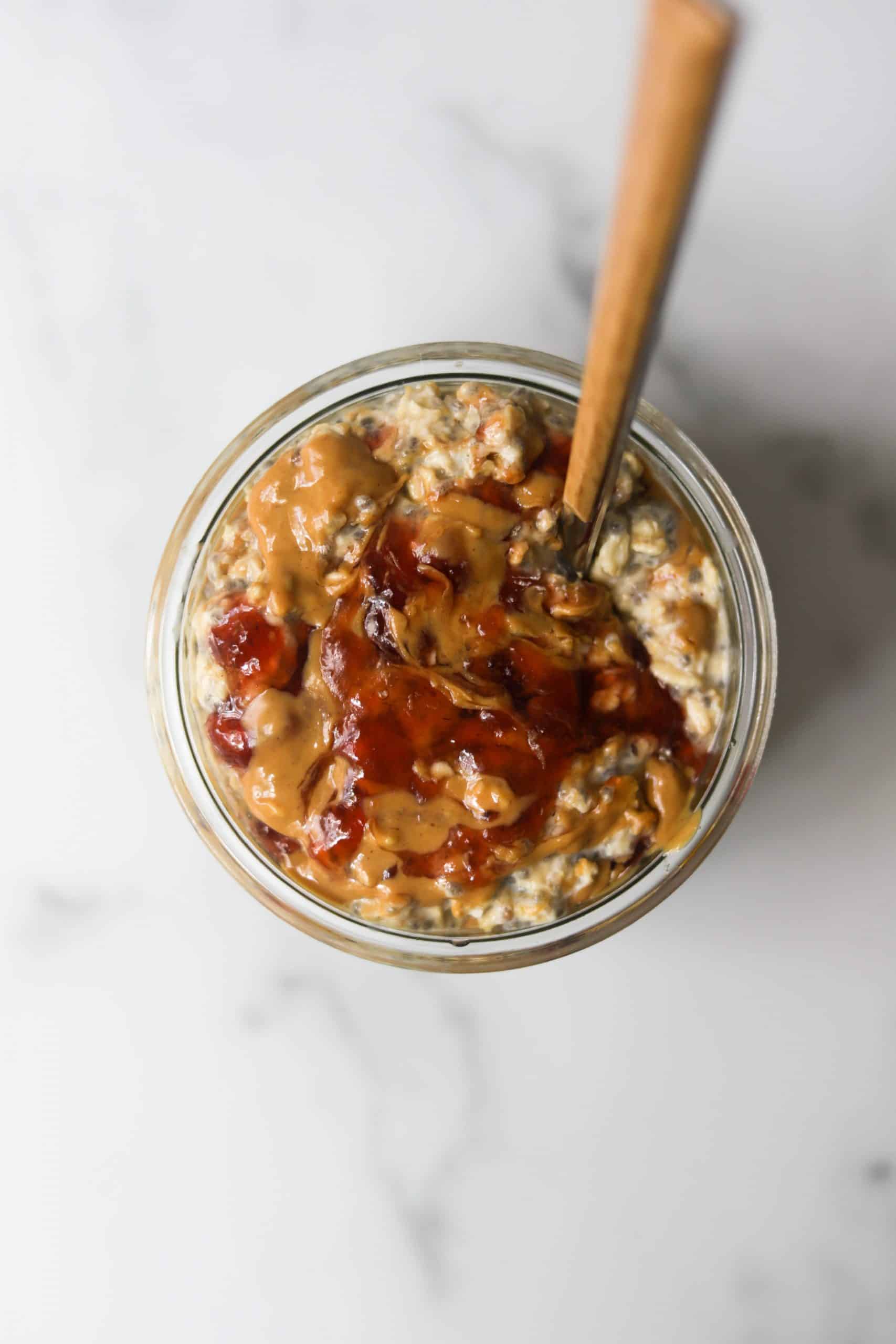 An overhead shot of a peanut butter and jelly overnight oats jar.