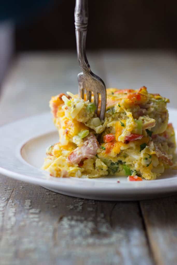 Breakfast casserole slices being forked on a plate