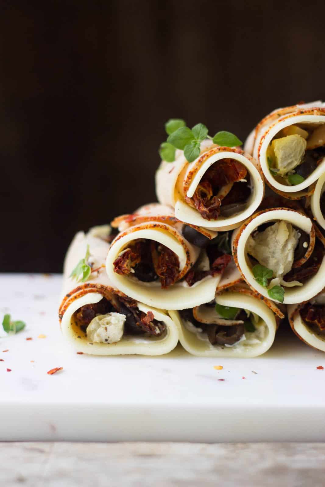 Side shot of antipasto roll-ups stacked on top of each other
