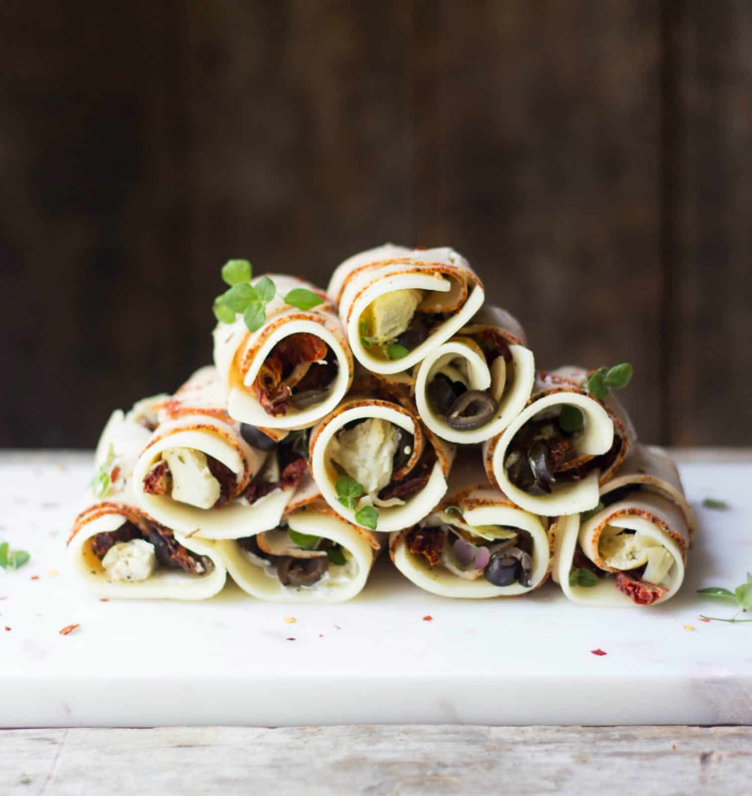 Turkey roll ups stacked on a marble board