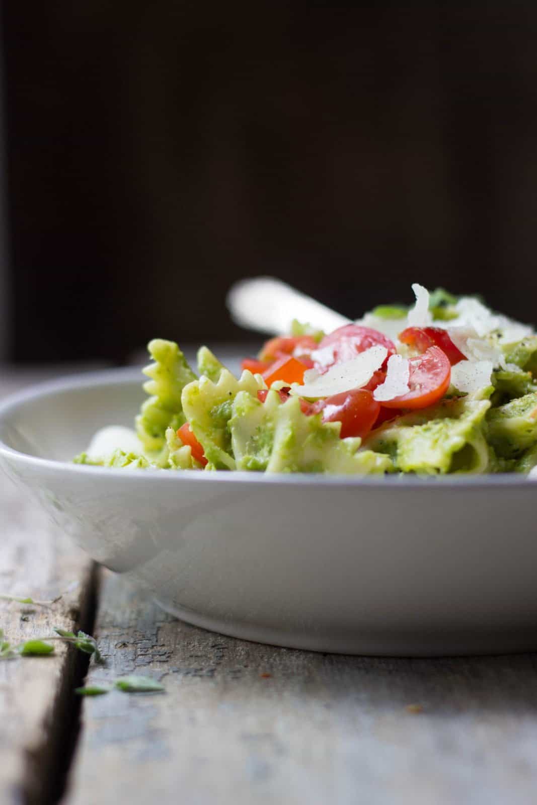 Caprese pasta salad with asparagus pesto in a white bowl