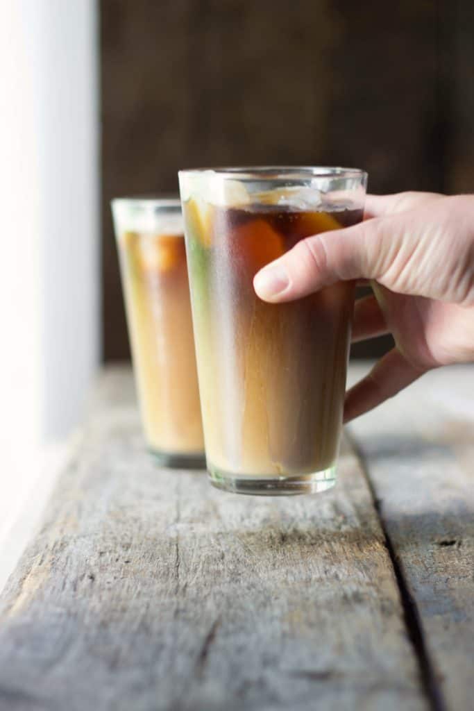 Hand holding a glass of iced americano. 