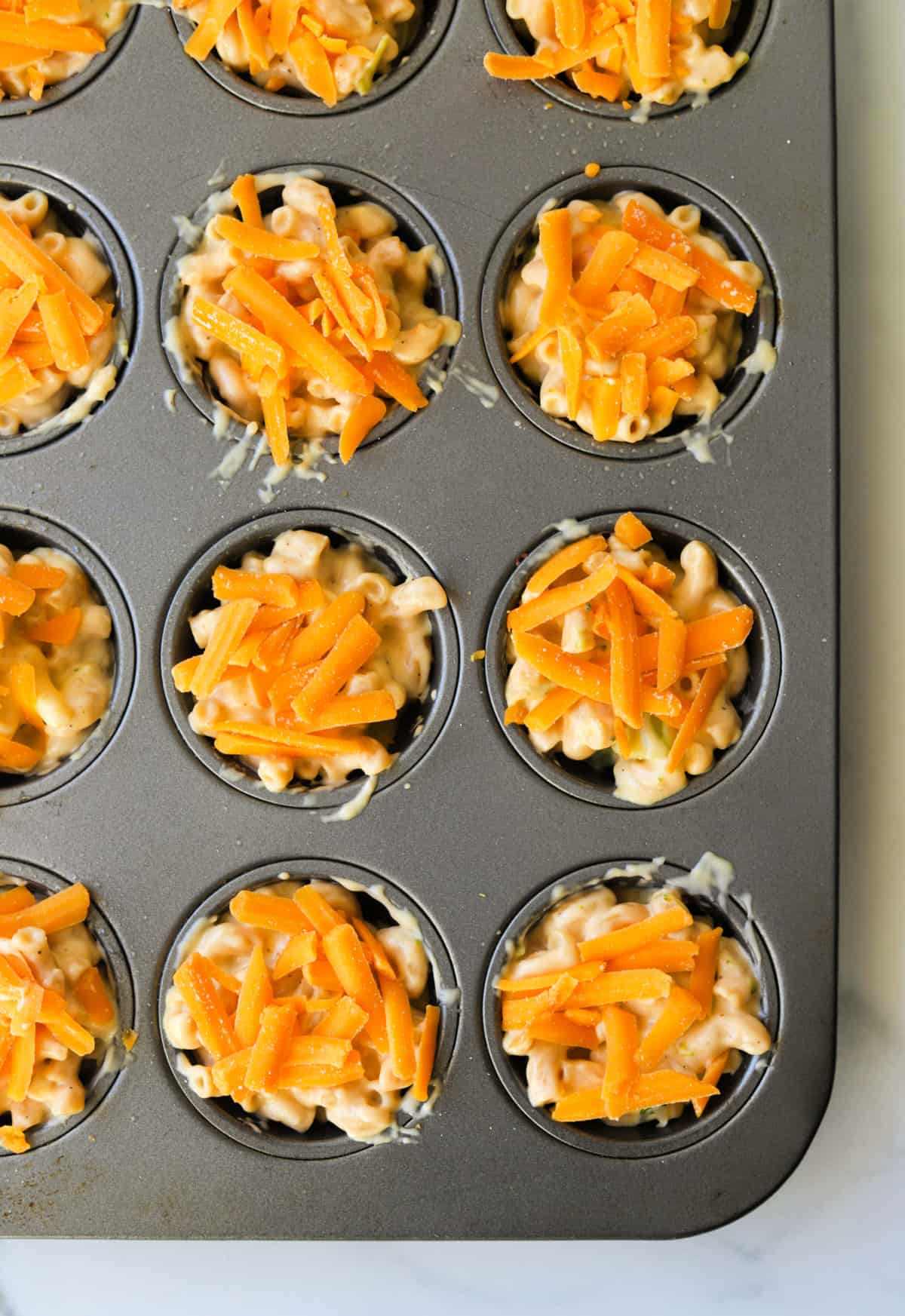 An overhead shot of macaroni and cheese in a muffin tin.