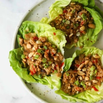 Cashew chicken lettuce wraps on a white speckled plate