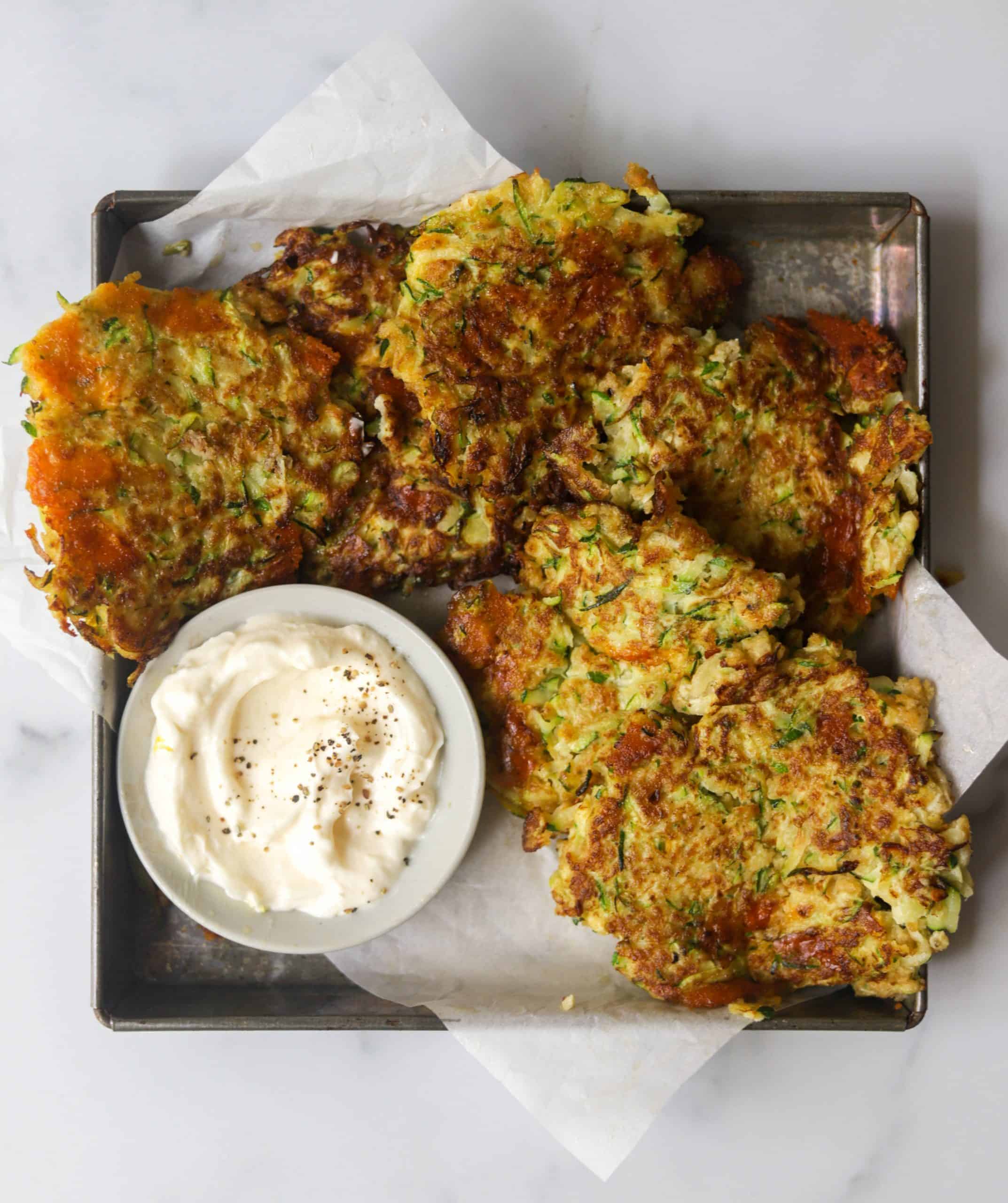 A metal tray with crispy zucchini fritters.