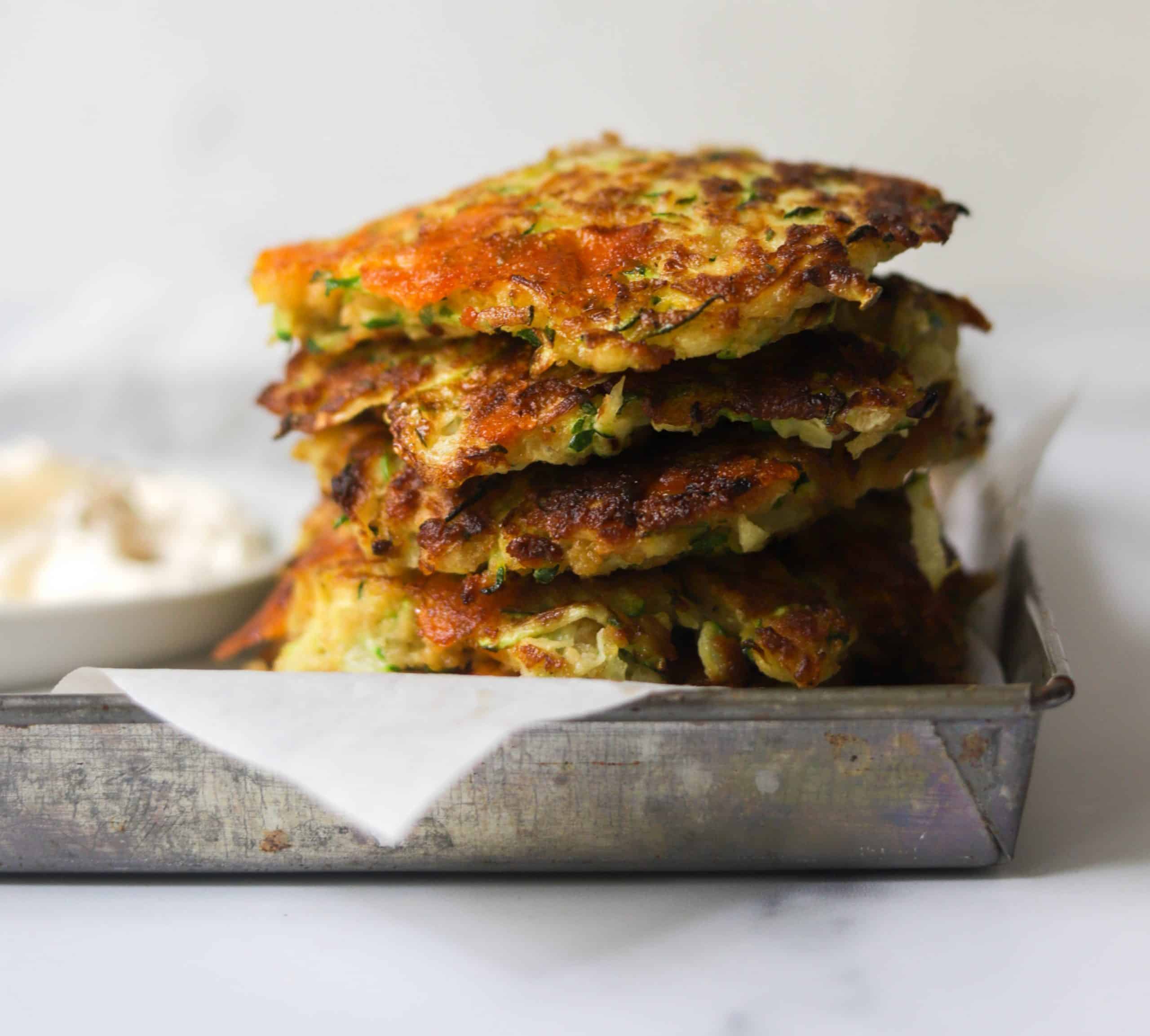 A side shot of a tray of zuchcini fritters.