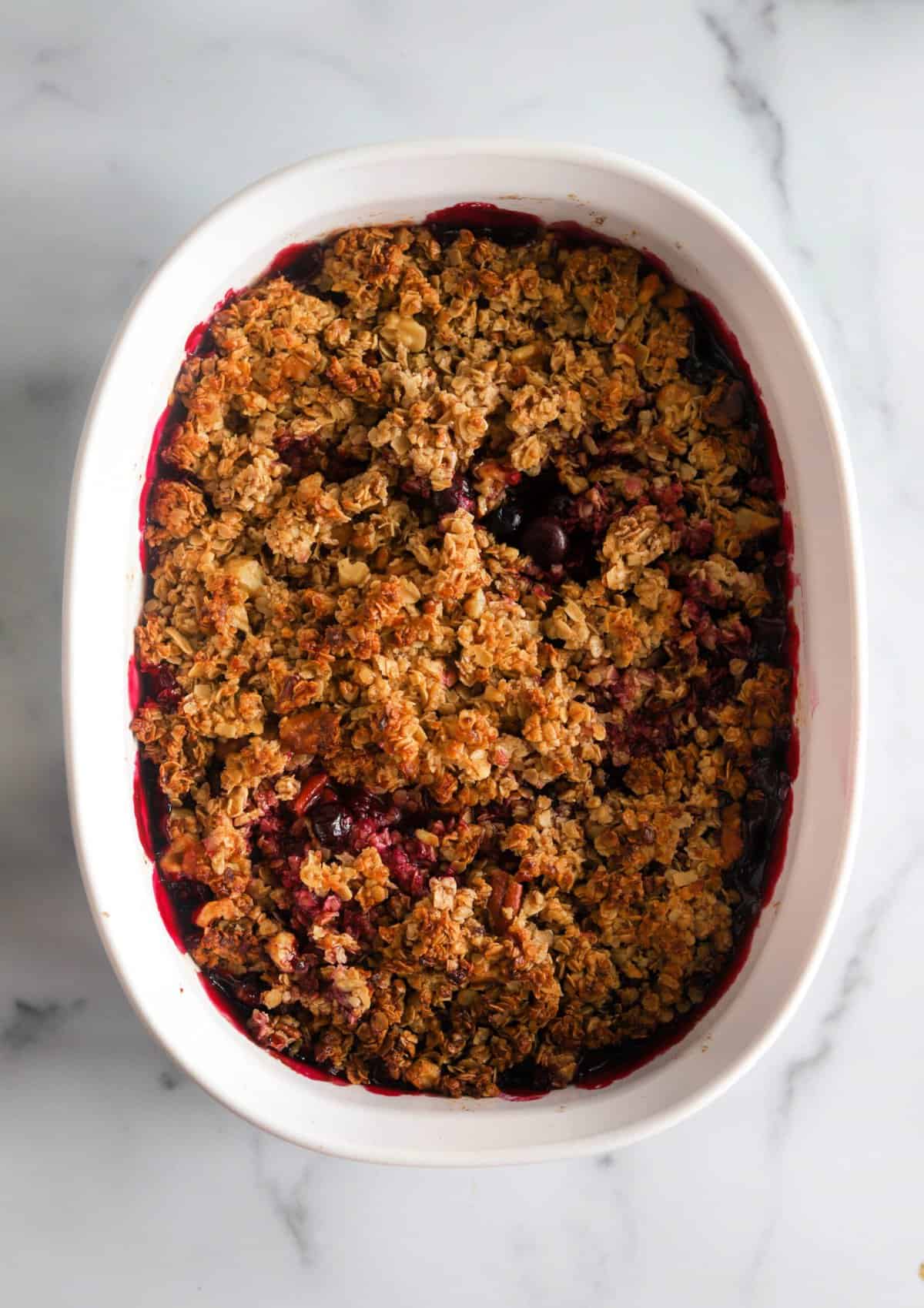 An overhead shot of a baking dish filled with blueberry crumble.