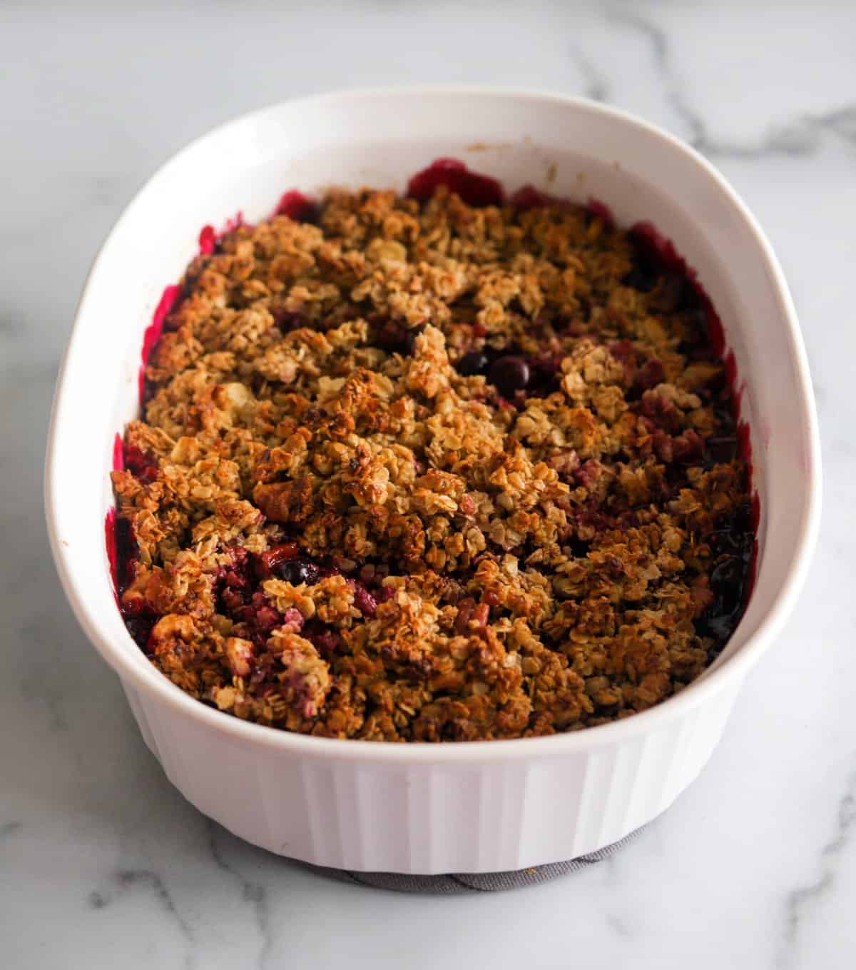 A side shot of a dish of healthy blueberry crumble.