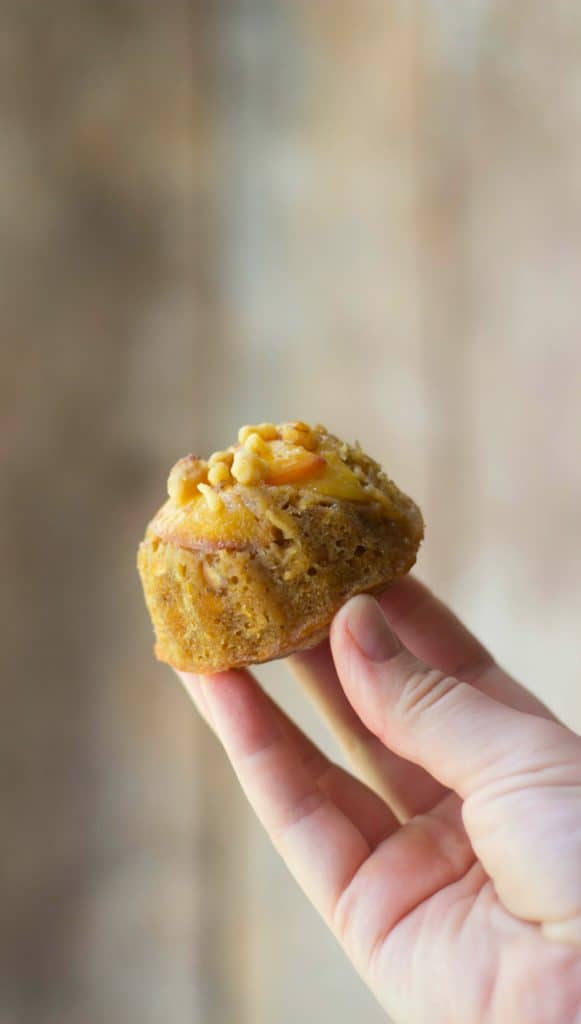 Mini peach bundt cake being held by a hand
