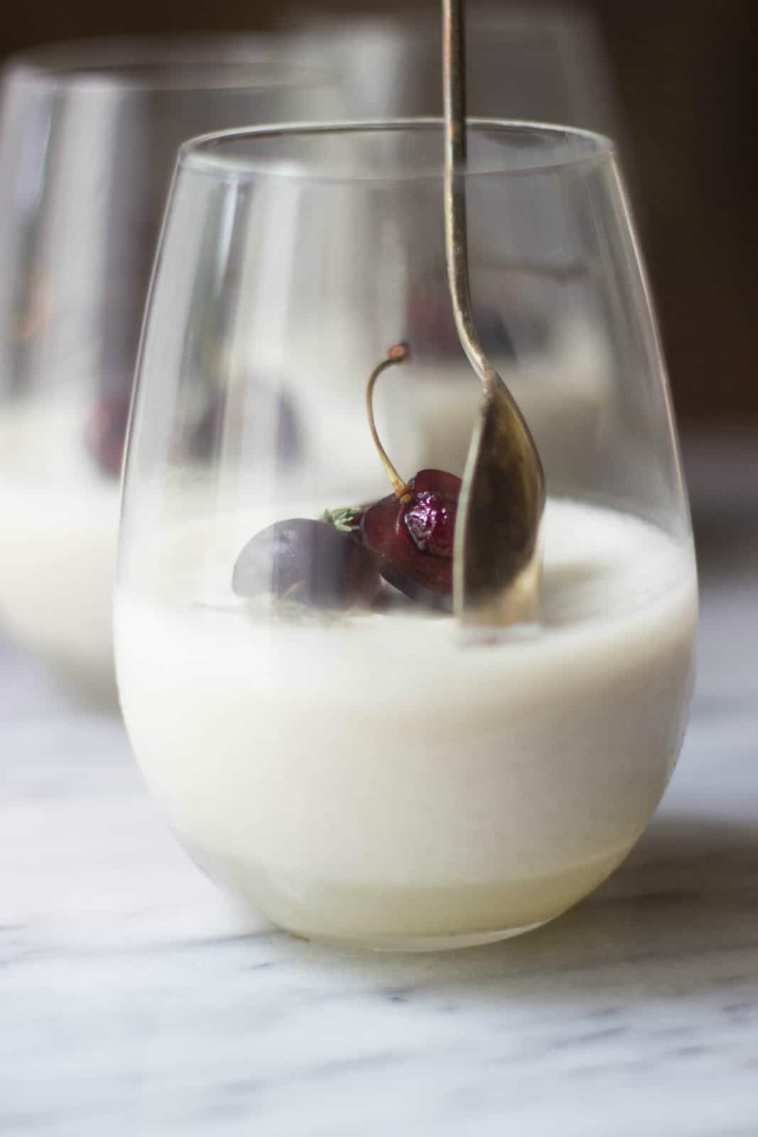 Close-up side shot of coconut milk panna cotta in a clear glass. 