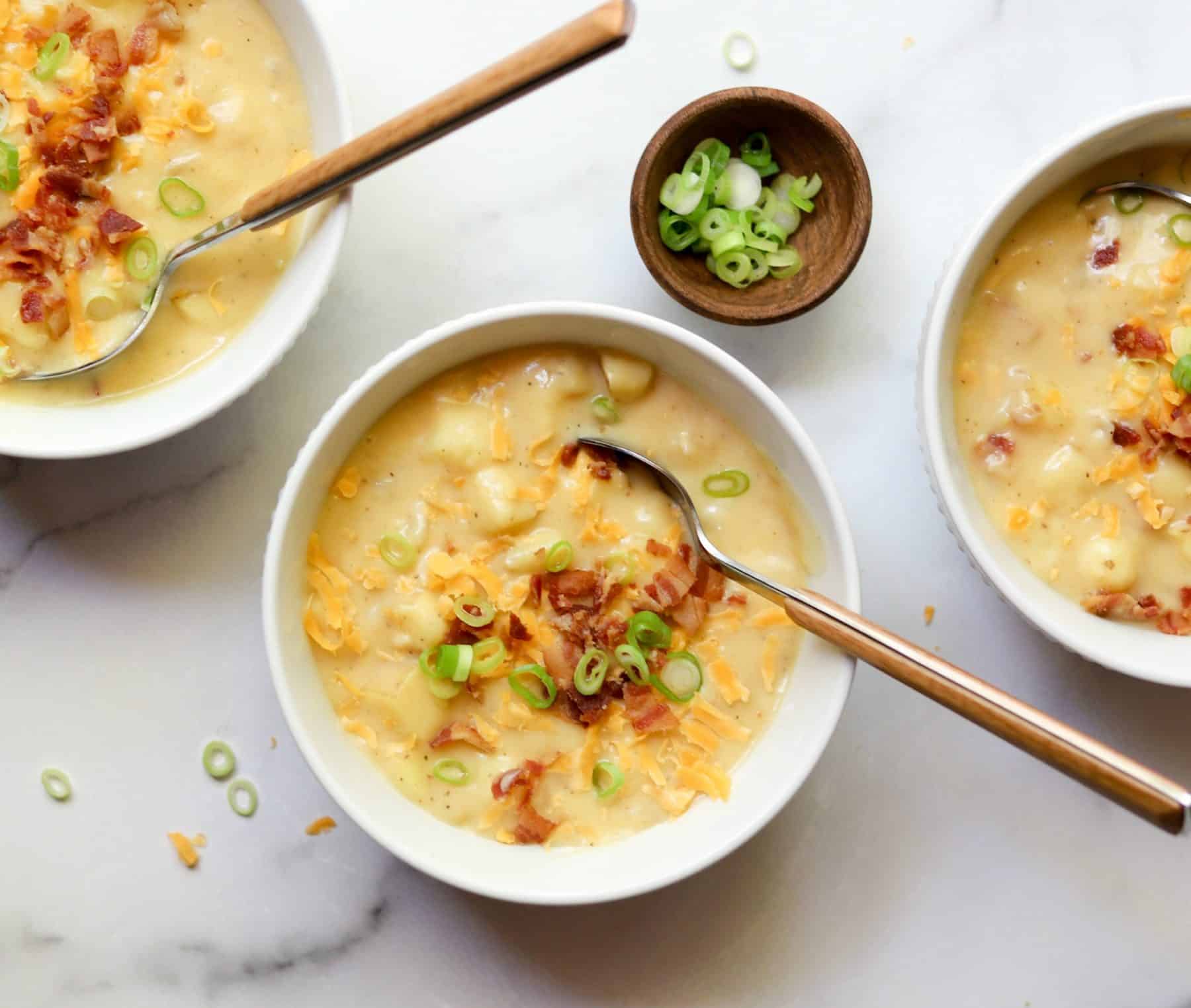 Cheesy potato soup in white bowls