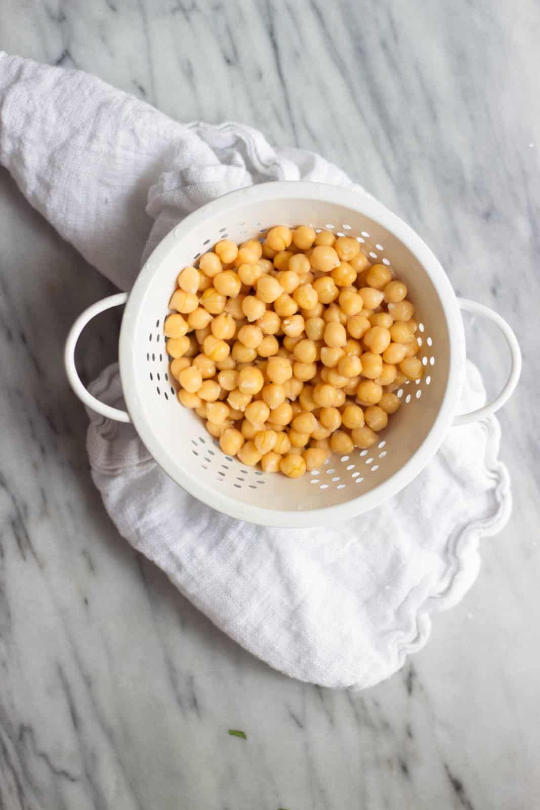 Overhead shot of chickpeas in a white colander.