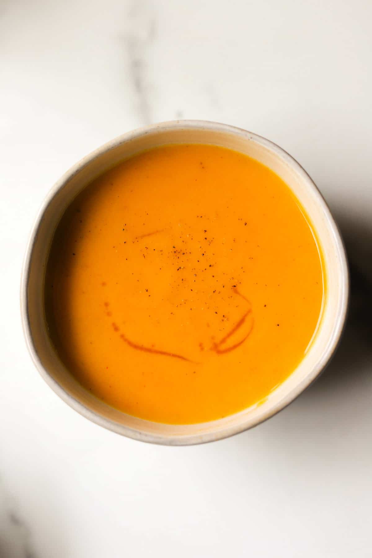 An overhead shot of a small bowl of maple sweet potato soup.