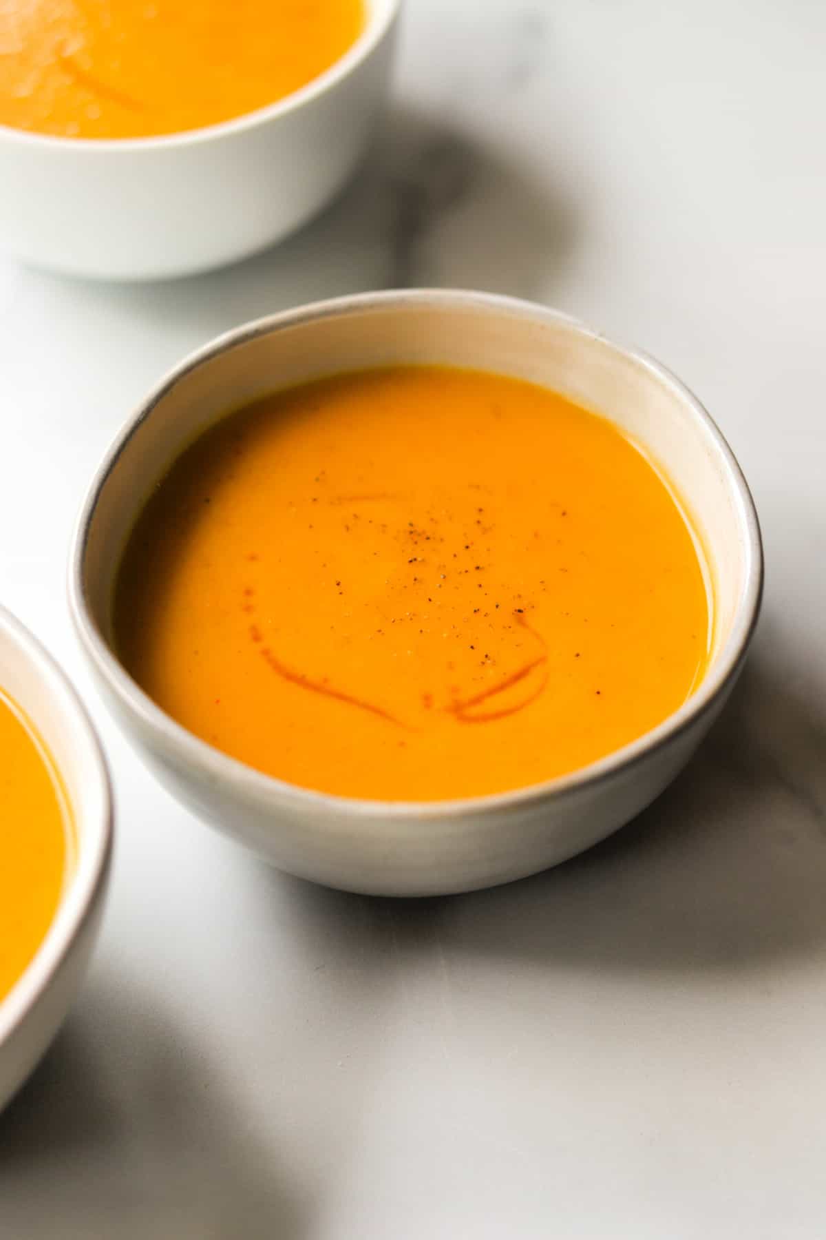 A side shot of bowls of sweet potato soup.