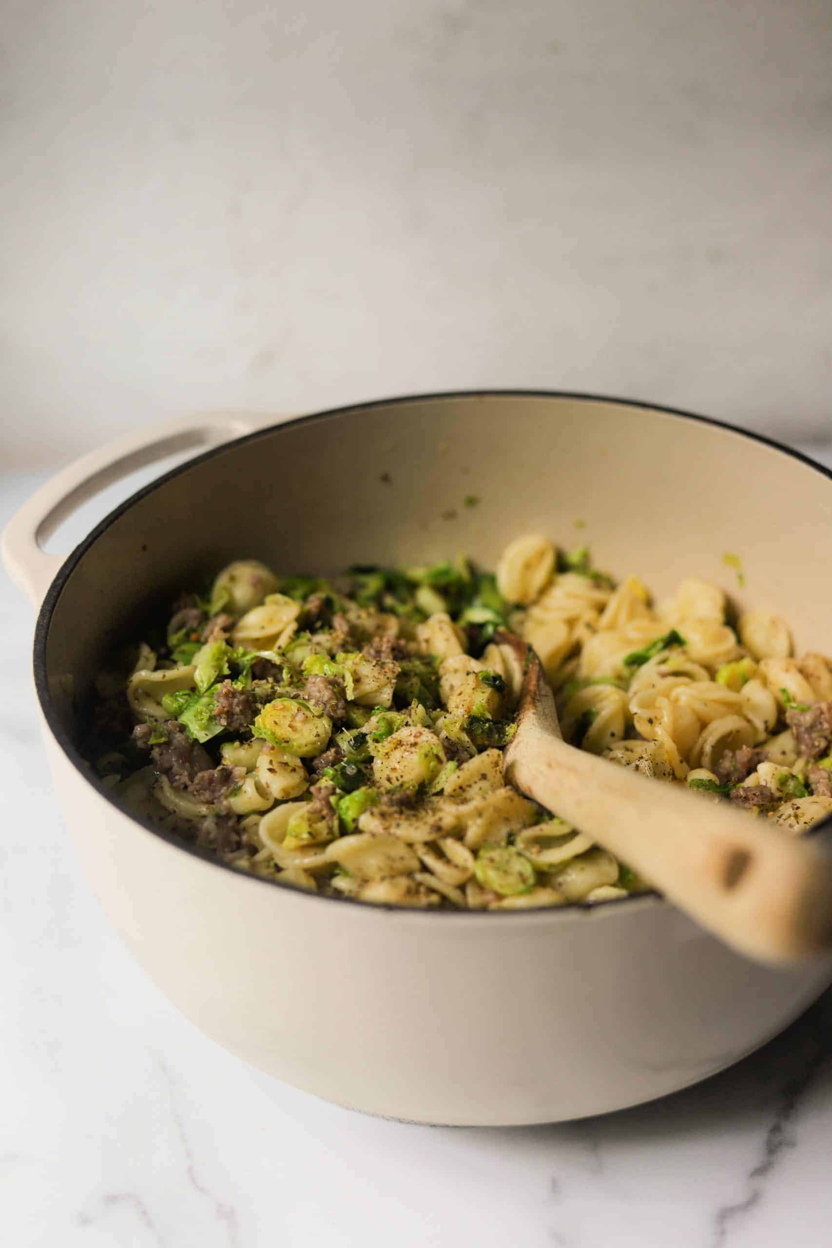 A white pot filled with Brussels sprouts pasta.