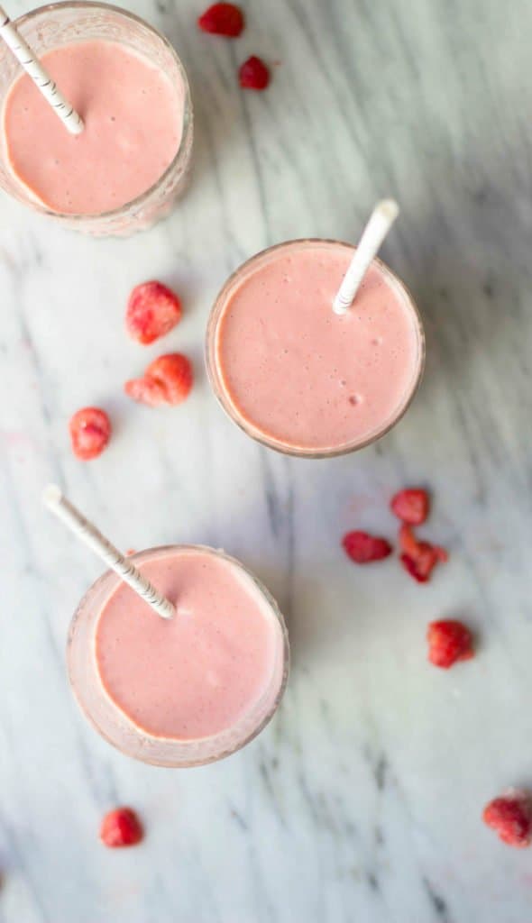 Strawberry Banana Cashew Smoothies shown from an overhead shot with strawberries sprinkled around.