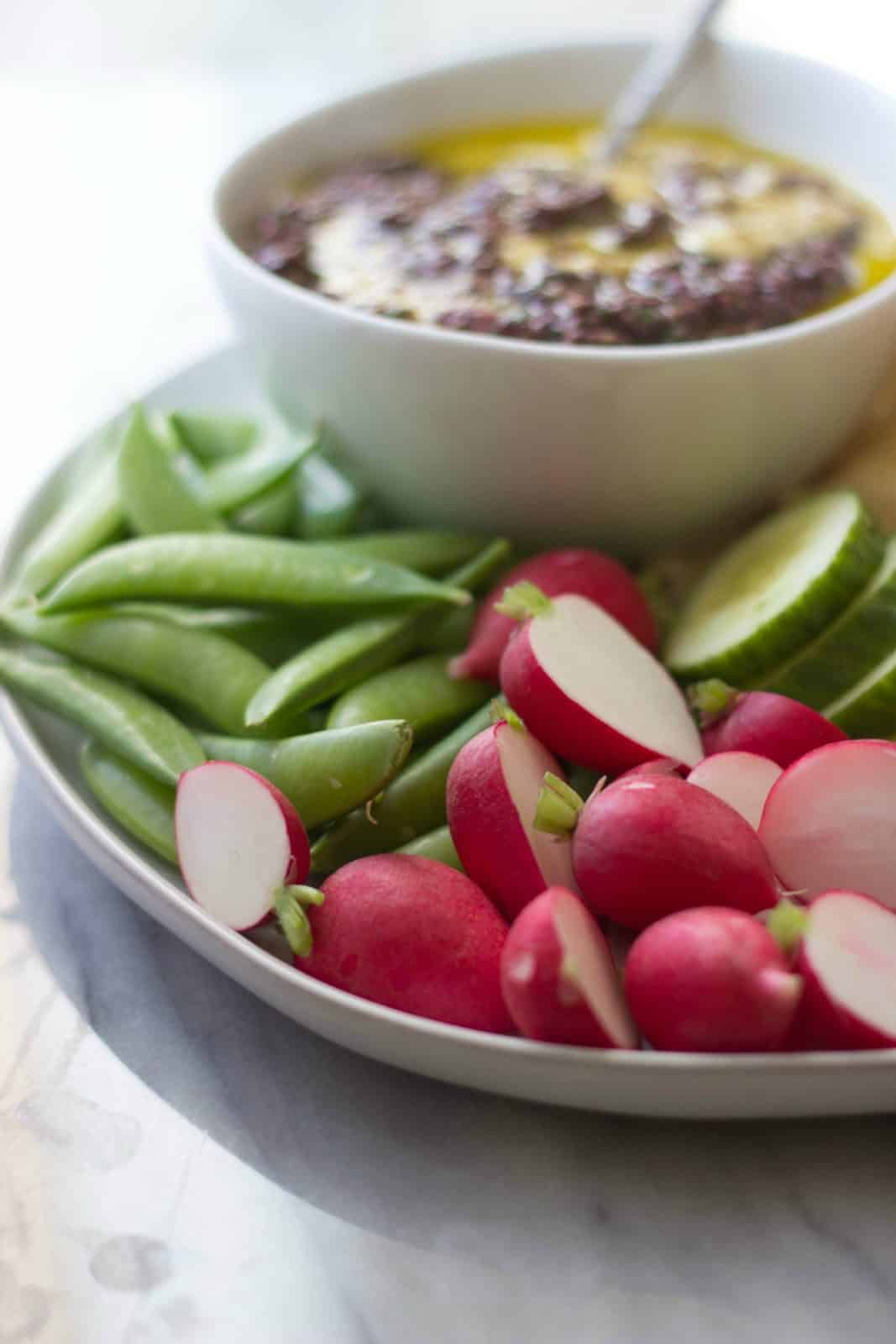 Close up of Greek Olive Hummus & Crudité Platter with a focus on fresh radishes