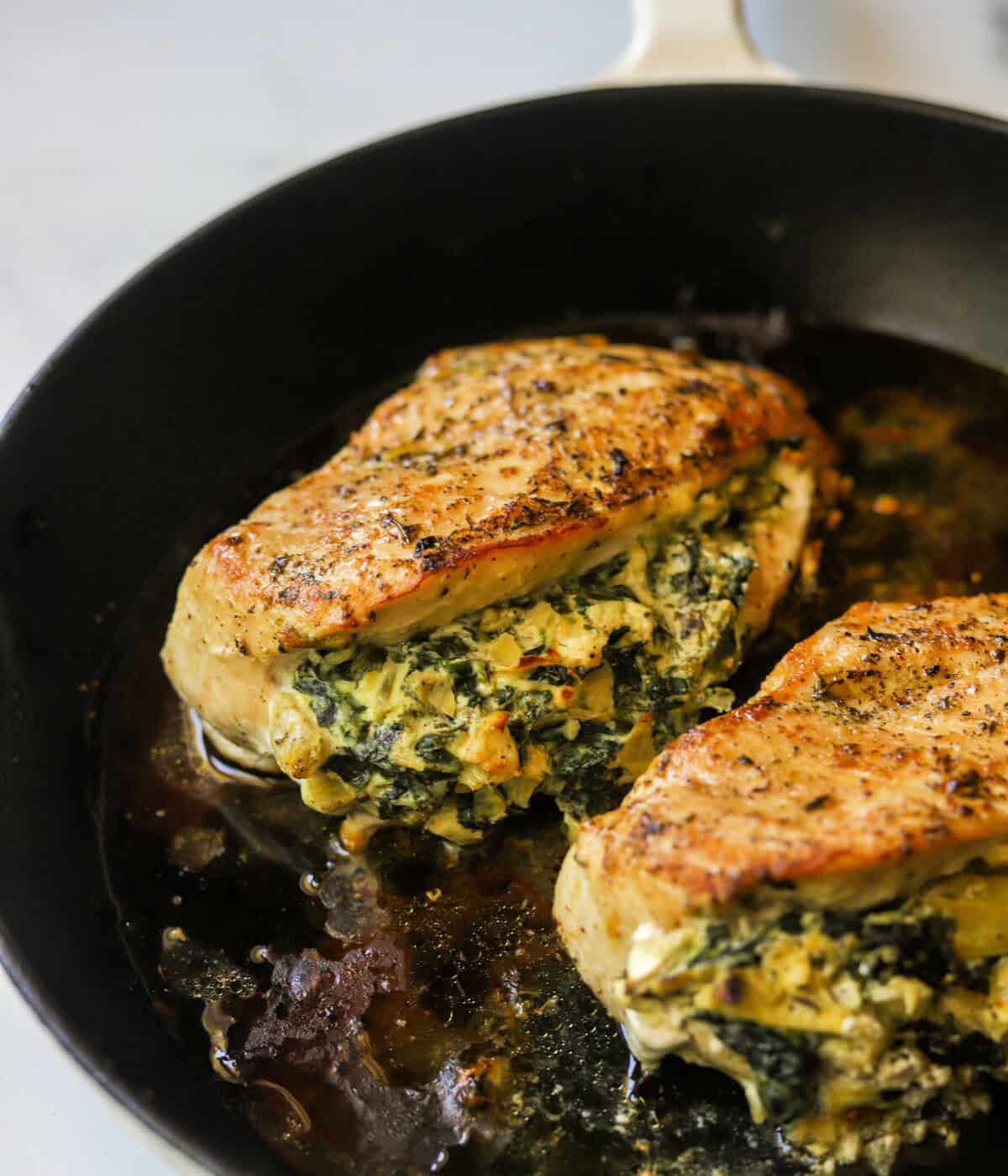 A front shot of spinach artichoke dip stuffed in chicken breasts.