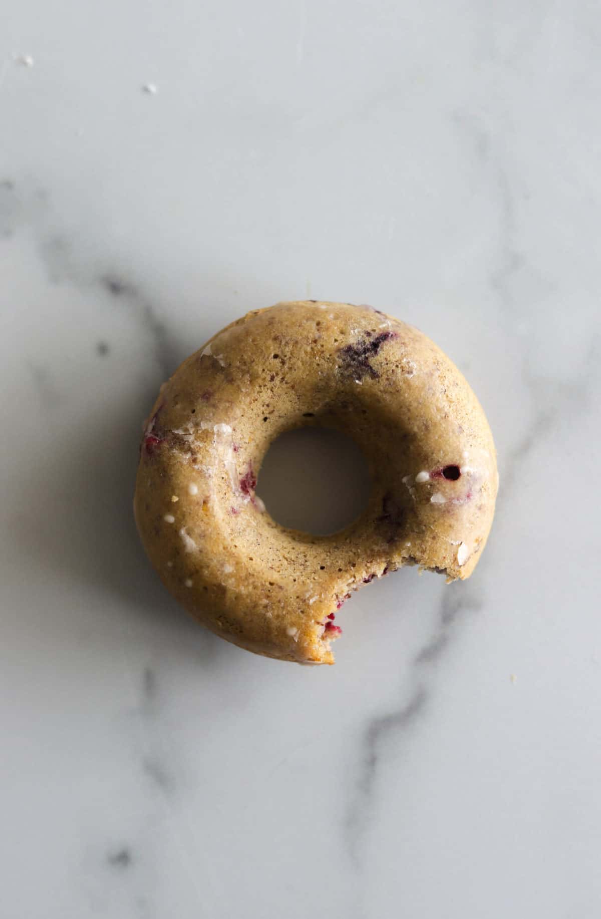 An overhead shot of one donut with a bite out of it.