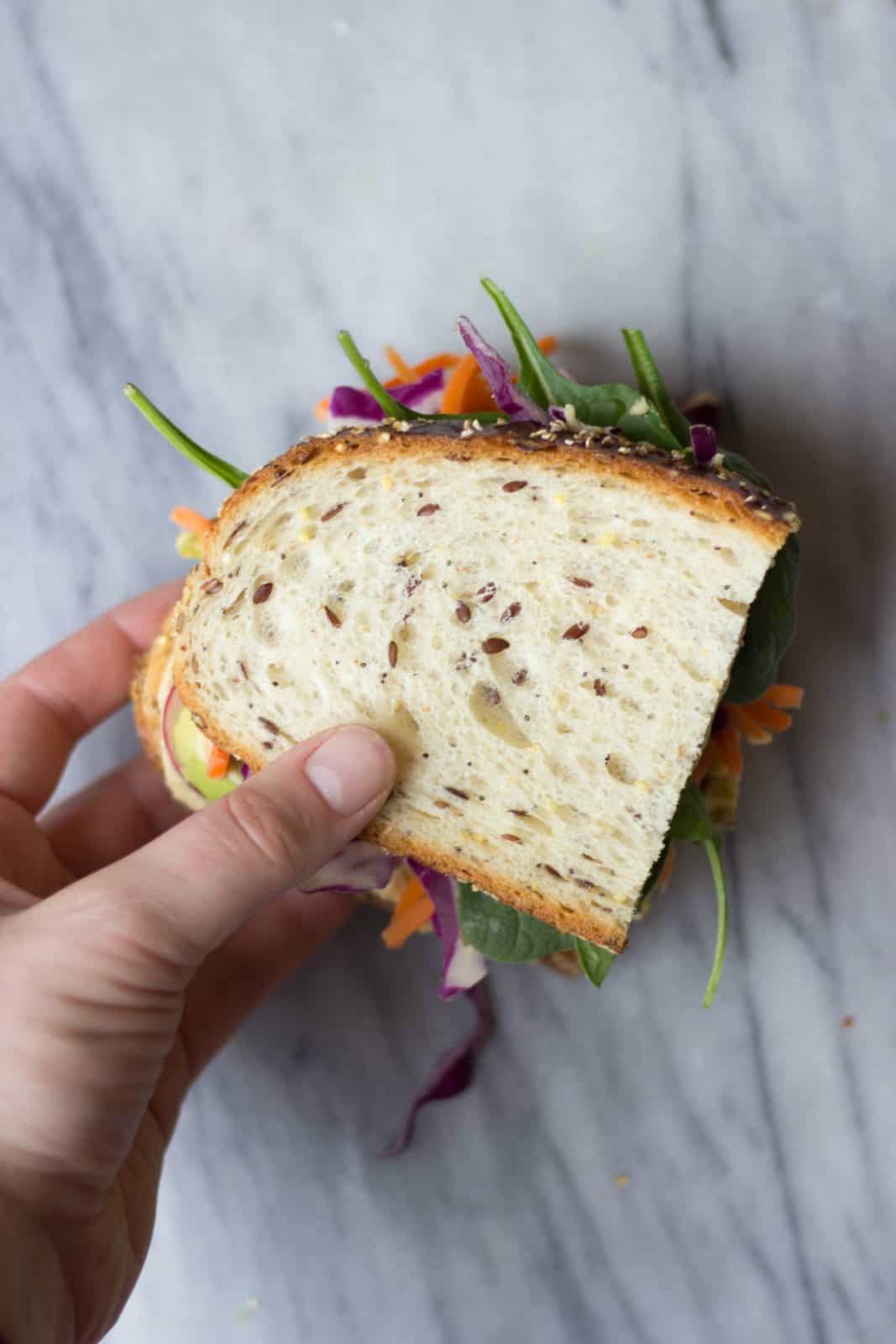 Overhead shot of a hand holding the  Ultimate Veggie Sandwich