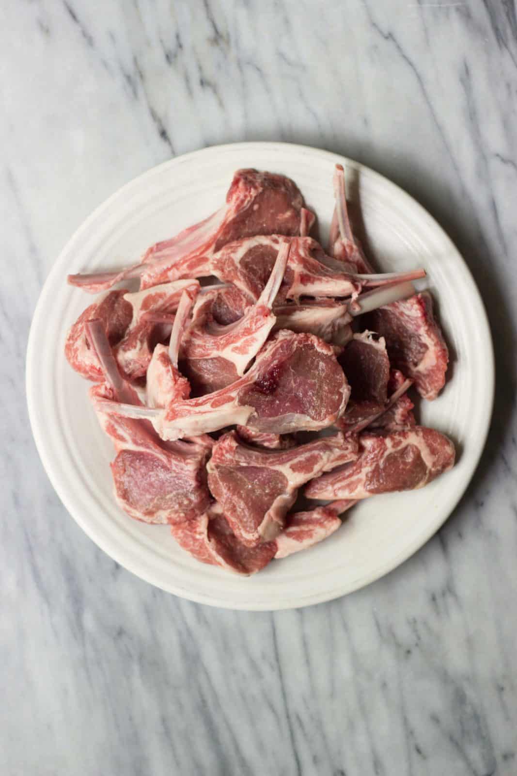 Raw lamb on a white plate.