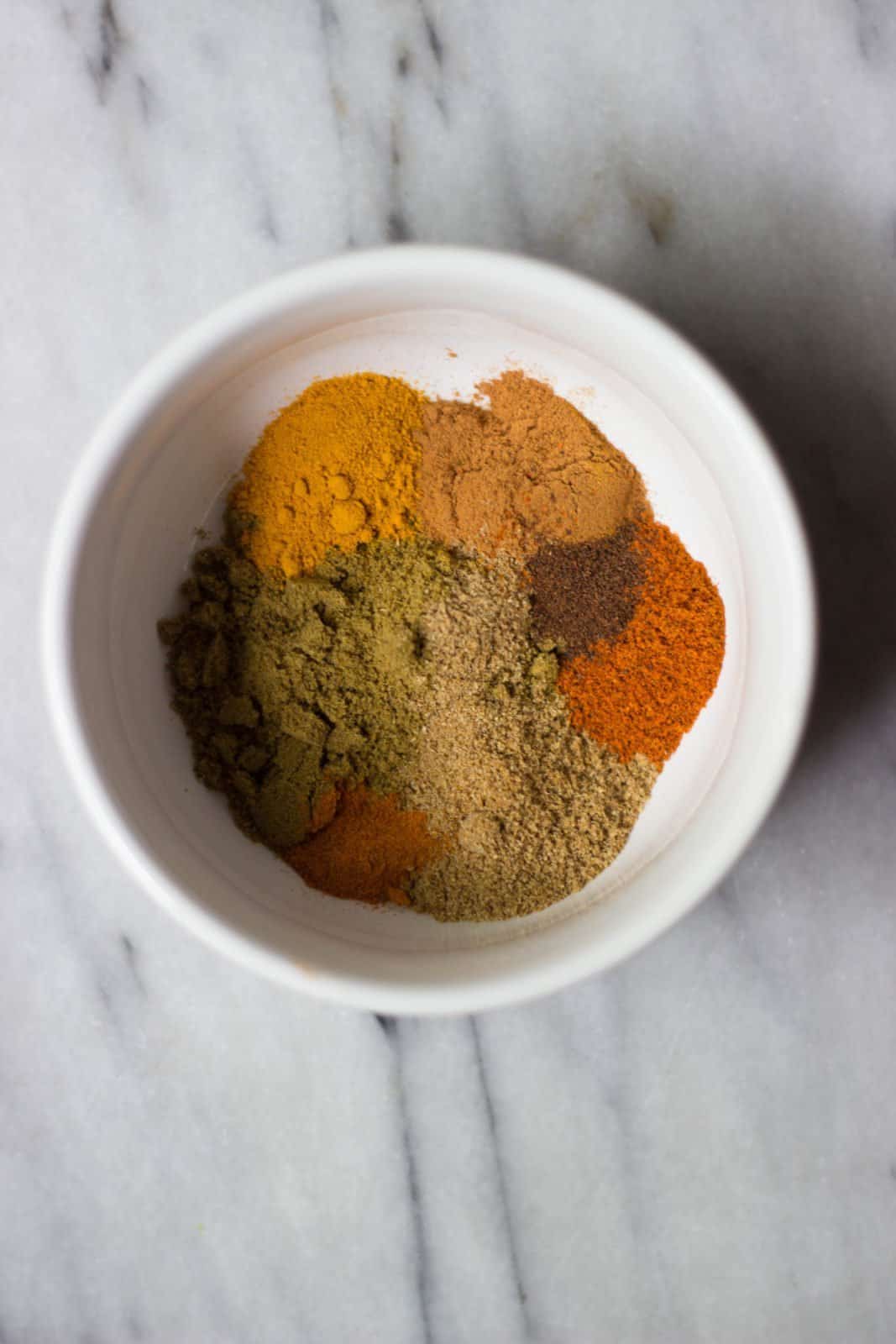 Overhead shot of spices in a white bowl.