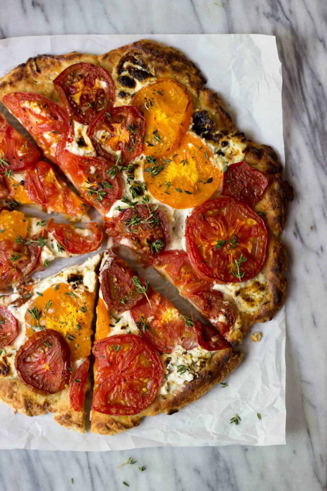 Rustic Heirloom Tomato Pizza on a marble board.