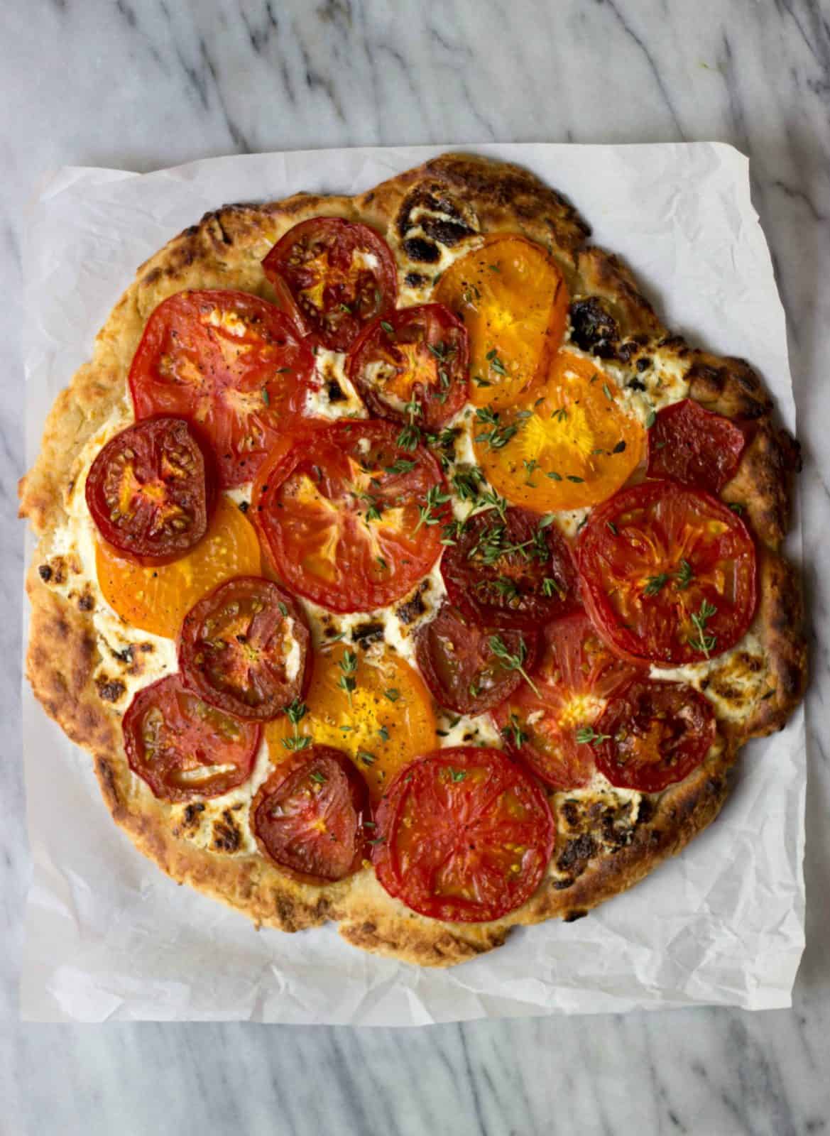 Rustic Heirloom Tomato Pizza on a marble board.