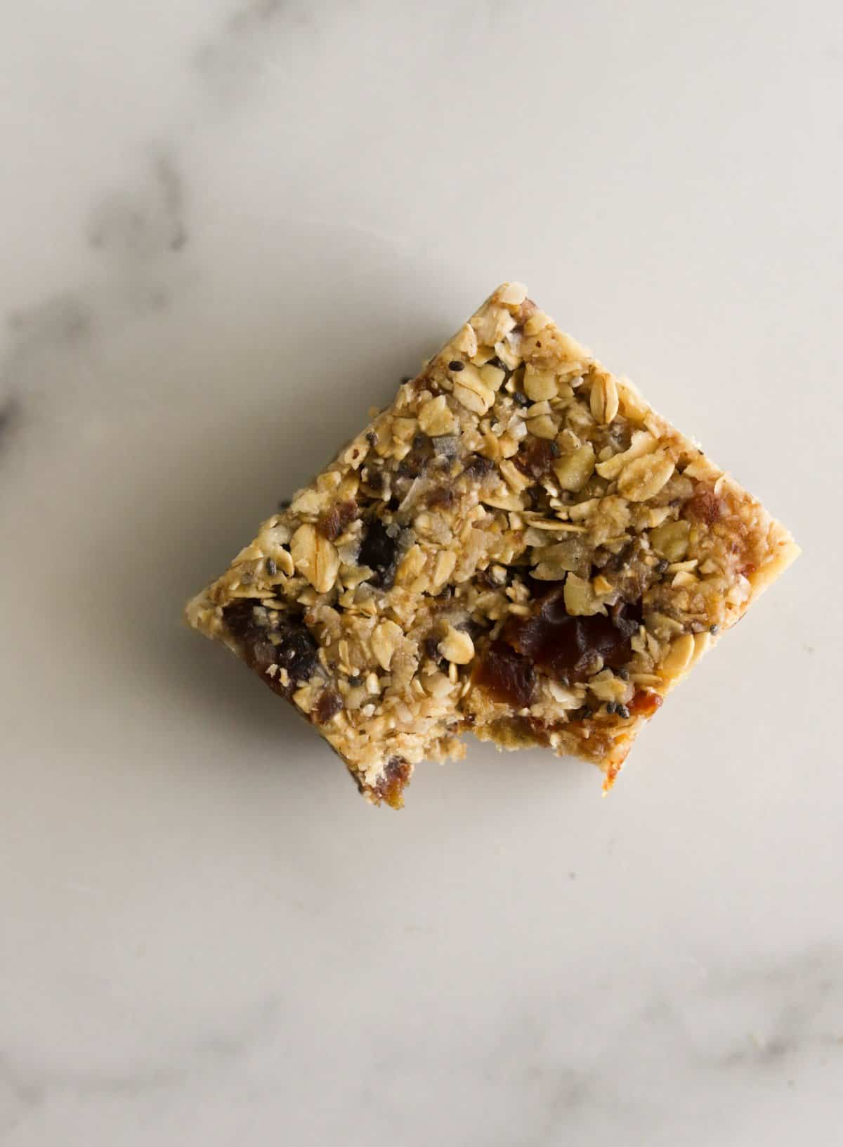An overhead shot of a date nut bar with a bite out of it.