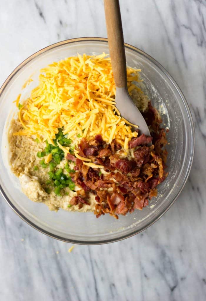 Cornbread muffin batter with cheddar, bacon and jalapeno in a bowl.