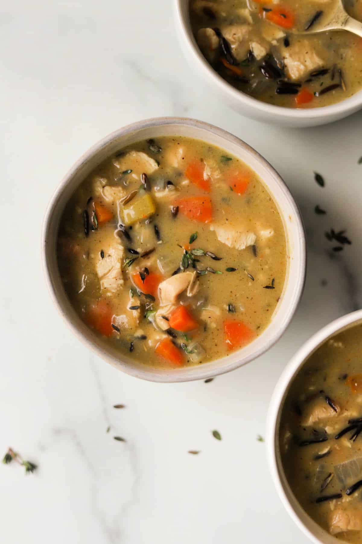 An overhead shot of bowls of chicken wild rice soup.