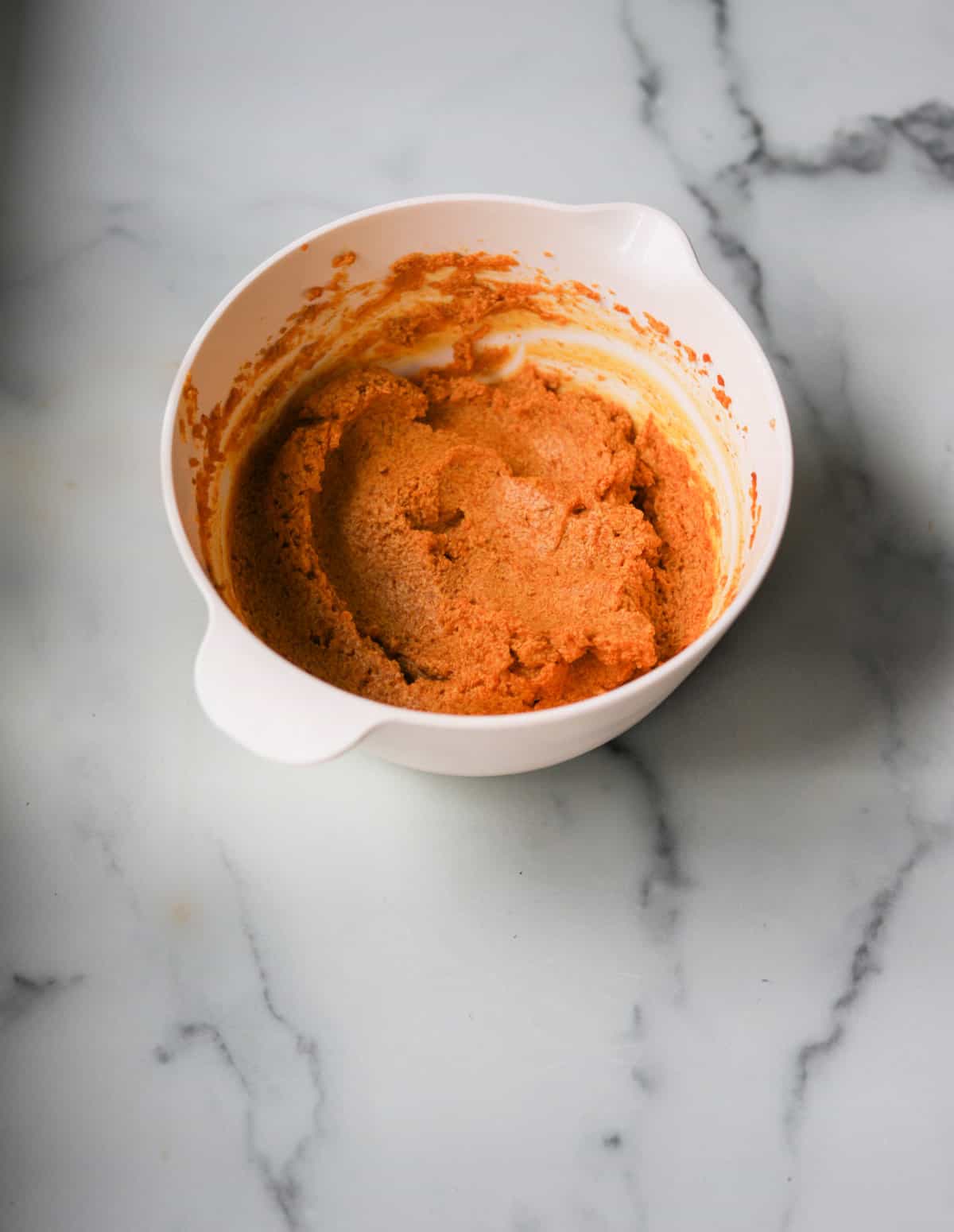 A front shot of a mixing bowl with pumpkin butter in it.