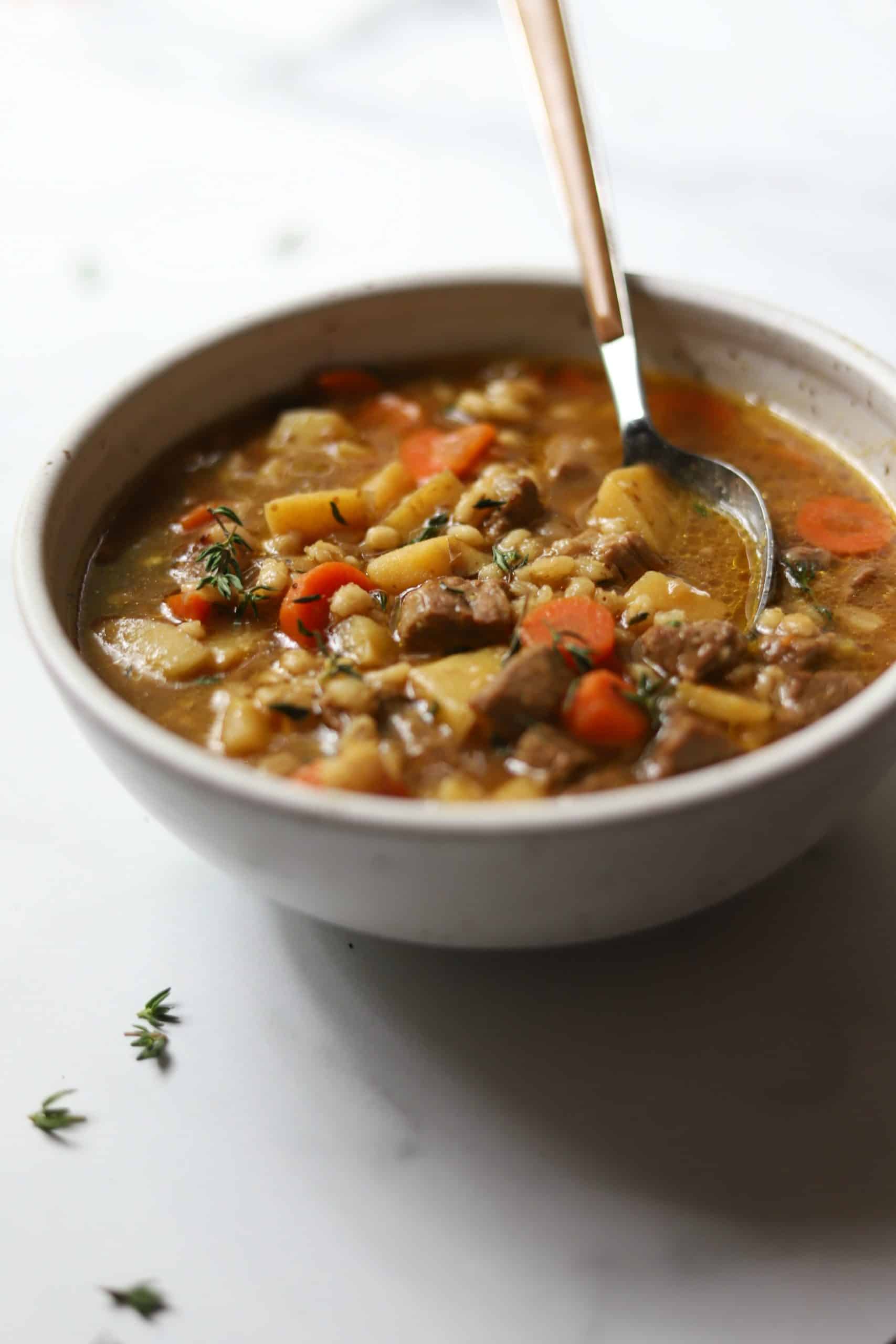 Beef barley soup in a white bowl