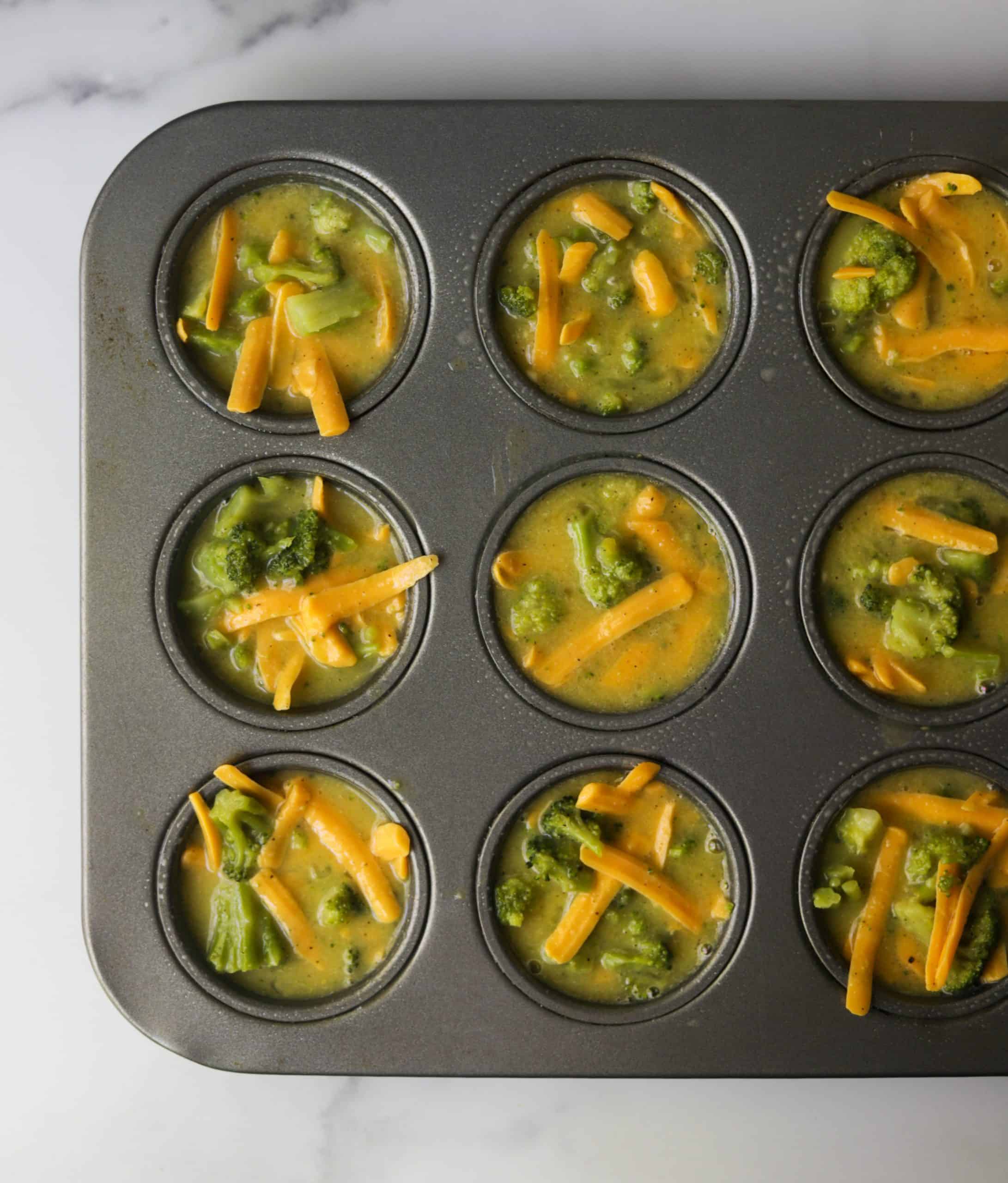 A muffin tin filled with broccoli cheese egg muffins.