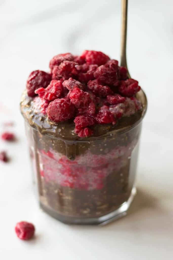 Angle shot of Chocolate Overnight Oats & Raspberry Chia Pudding Parfaits in a glass cup